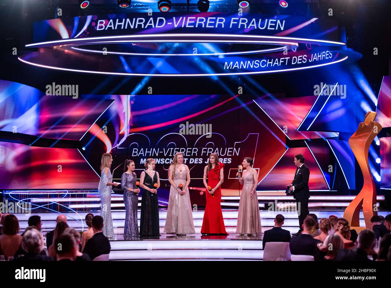 Baden Baden, Deutschland. 19th Dez 2021. Das vierköpfige Damen-Rennradteam mit Lisa Klein, Franziska Brausse, Mieke Kroeger, Laura Suessemilch und Lisa Brennauer steht mit den Moderatoren Katrin Müller-Hohenstein (l) und Rudi Cerne (r) während der Verleihung des Preises „Team des Jahres“ bei der Verleihung des Preises „Sports Person des Jahres 2021“ auf der Bühne. Kredit: Tom Weller/dpa-Pool/dpa/Alamy Live Nachrichten Stockfoto