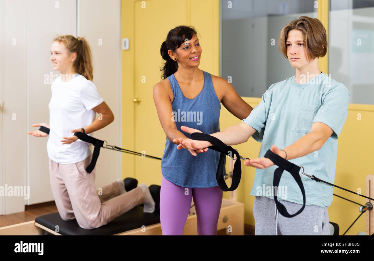 Teens tun Pilates Übungen mit Trainer Stockfoto