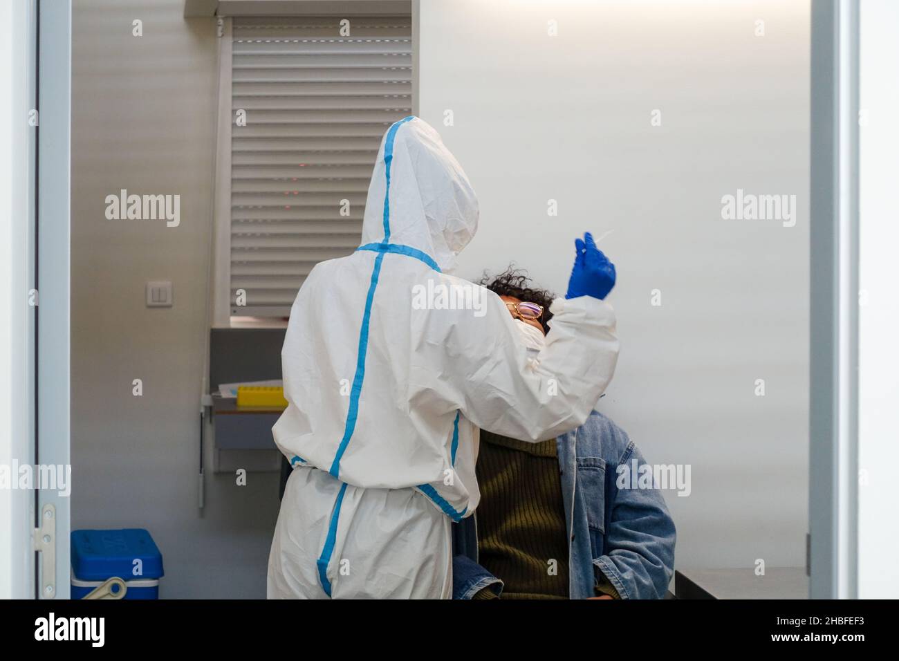 Schwarze Frau, die vor dem Einsteigen in den Flughafen Faro, Portugal, einen Schnelltest (SARS-CoV-2 Rapid Antigen Test) von einer Krankenschwester mit einem Nasenabstrich in der Hand abnimmt Stockfoto