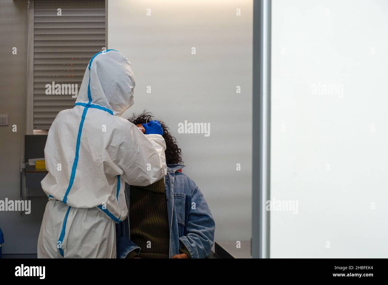 Medizinisches Fachpersonal, das einen Nasenabstrich für einen SARS-cov2-Schnellantigen-Test an einer schwarzen Frau durchführt Stockfoto