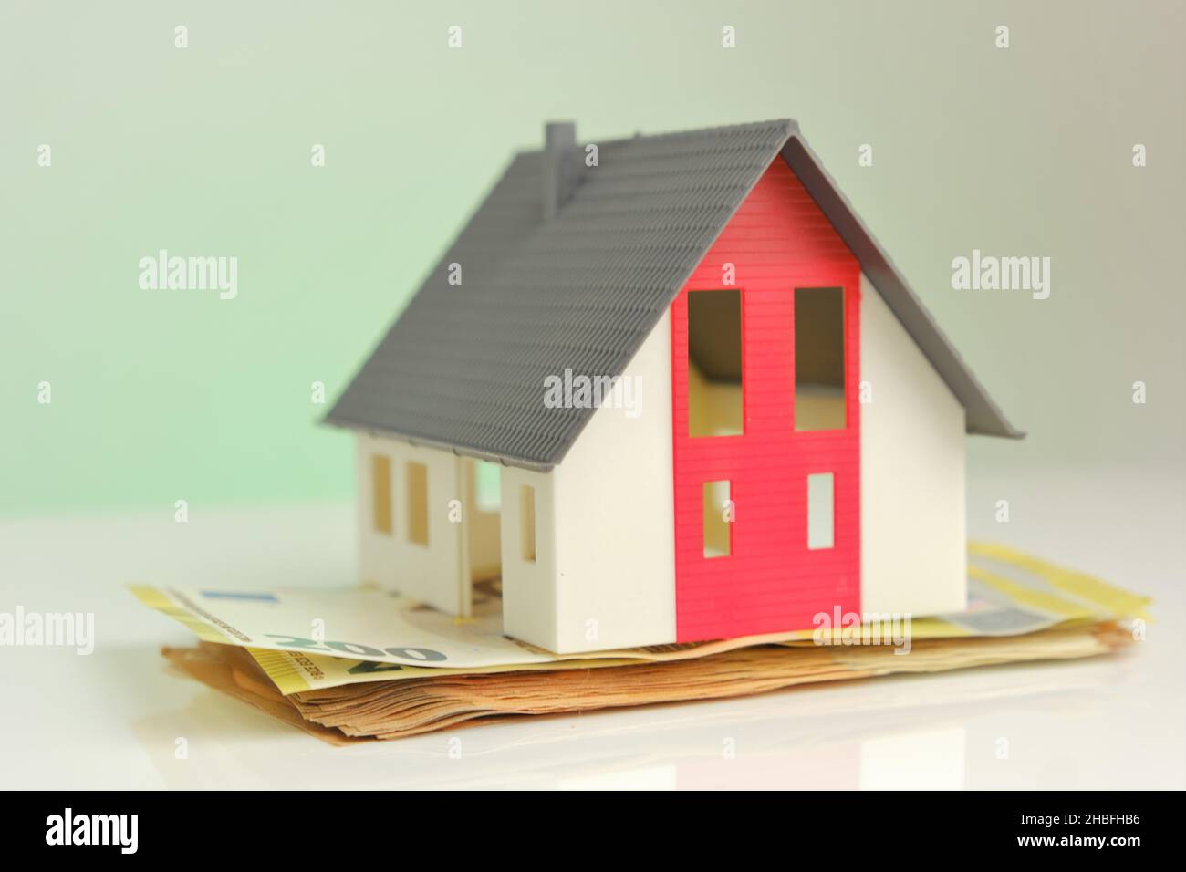 Scheinhaus mit Dach auf Euro-Banknoten Hintergrund. Immobilienmarkt. Immobiliendarlehen. Stockfoto