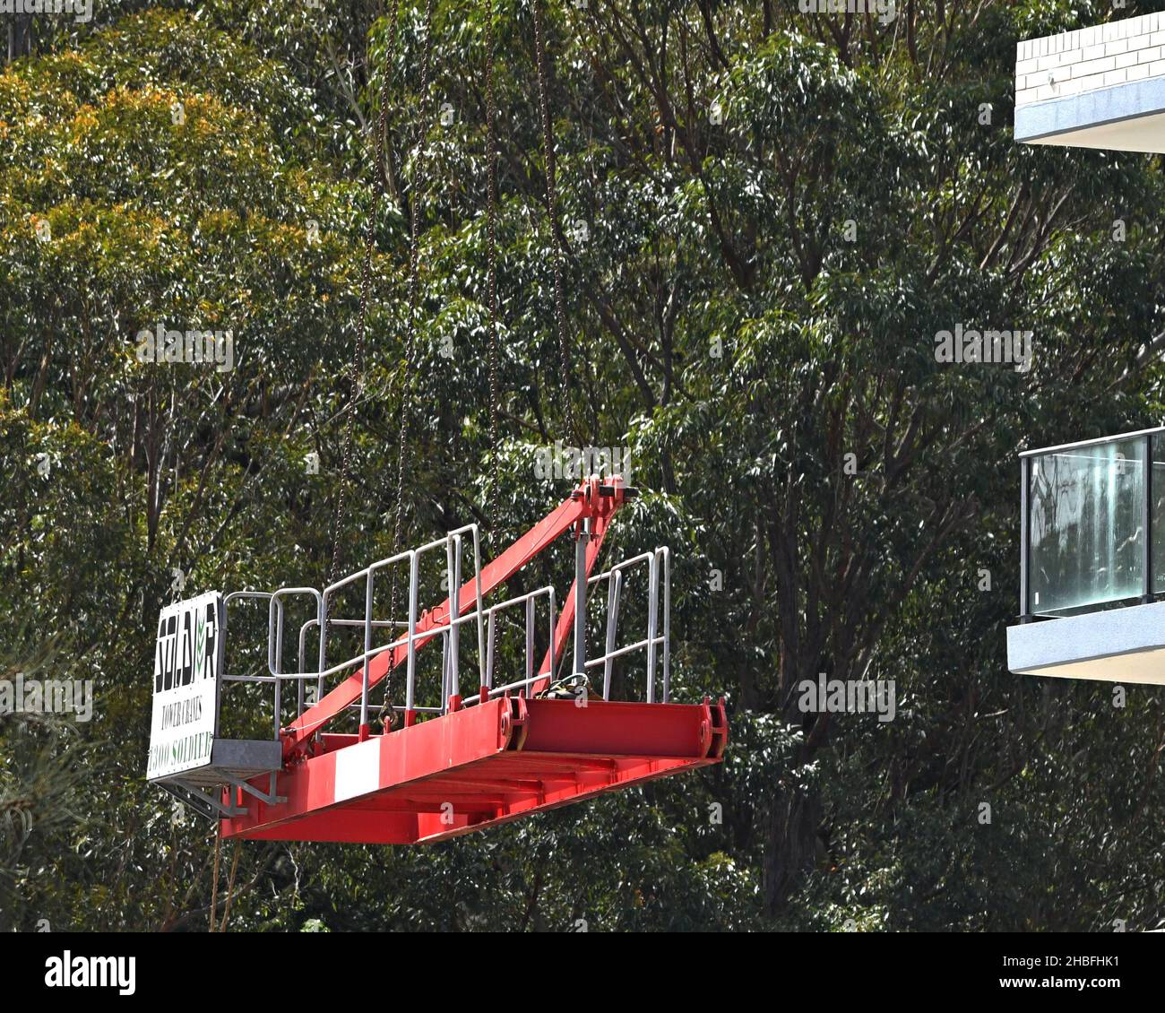 10:19 Uhr 7. Dezember 2021: Gosford, NSW, Australien. Arbeiter, die den Turmdrehkran vor Ort demontieren (Entfernen der Gegenvorrichtung), auf dem Sozialwohnungsgelände bei Stockfoto
