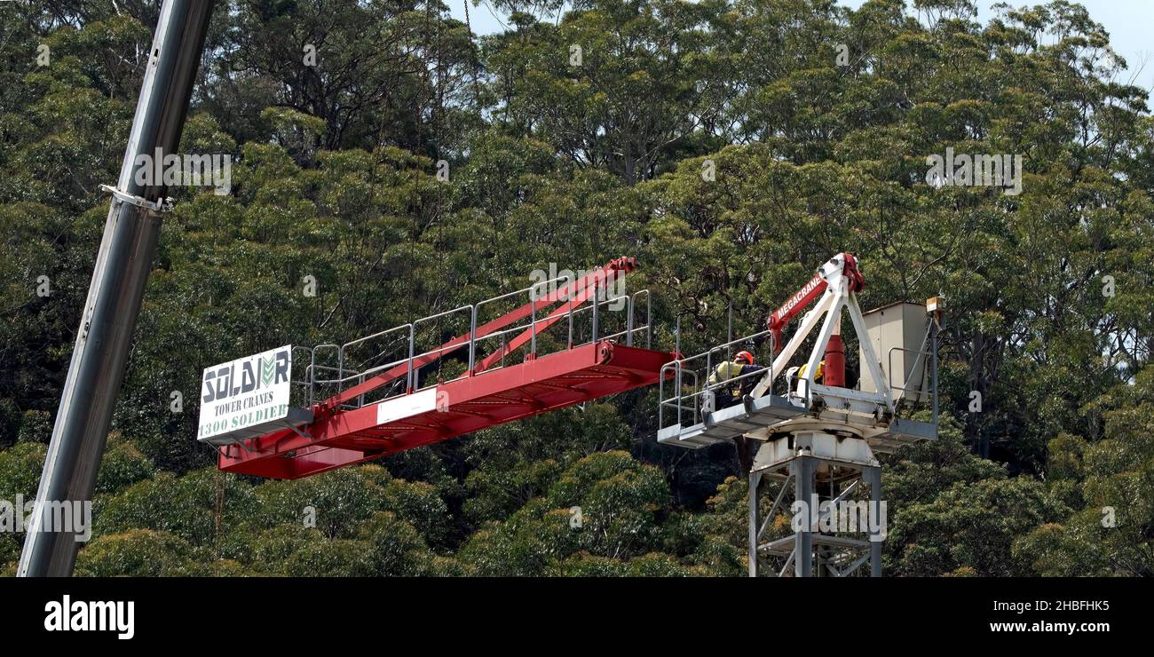10:18 Uhr 7. Dezember 2021: Gosford, NSW, Australien. Arbeiter, die den Turmdrehkran vor Ort demontieren (Entfernen der Gegenvorrichtung), auf dem Sozialwohnungsgelände bei Stockfoto