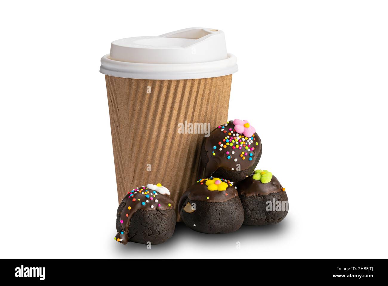 Stapel von Schokoladenkugeln mit Regenbogenstreuseln und Zuckerblumen und einer Papiertasse Kaffee auf weißem Hintergrund mit Schneideweg. Stockfoto