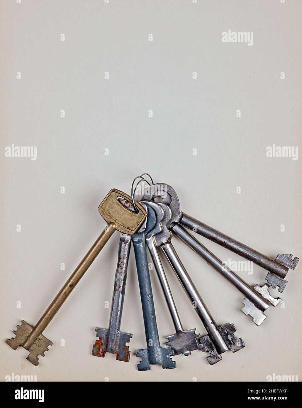 Stapel alter Schlüssel auf dem Papierhintergrund Stockfoto