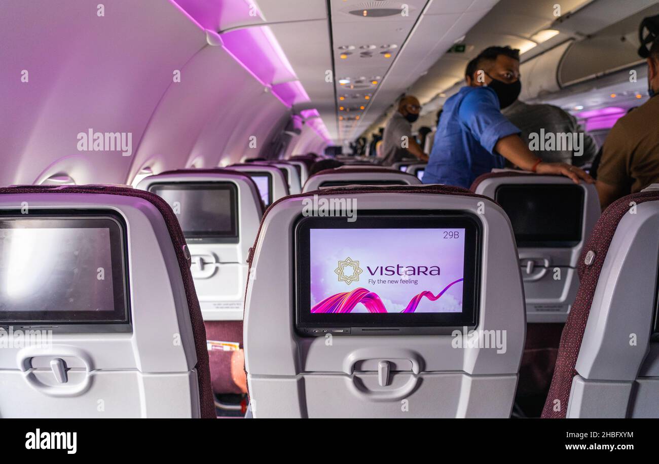 Der Airbus A321 von Vistara Airlines verfügt über Inflight-Entertainment-Bildschirme in der Economy-Kabine. Menschen, die im Hintergrund deplanieren. Stockfoto