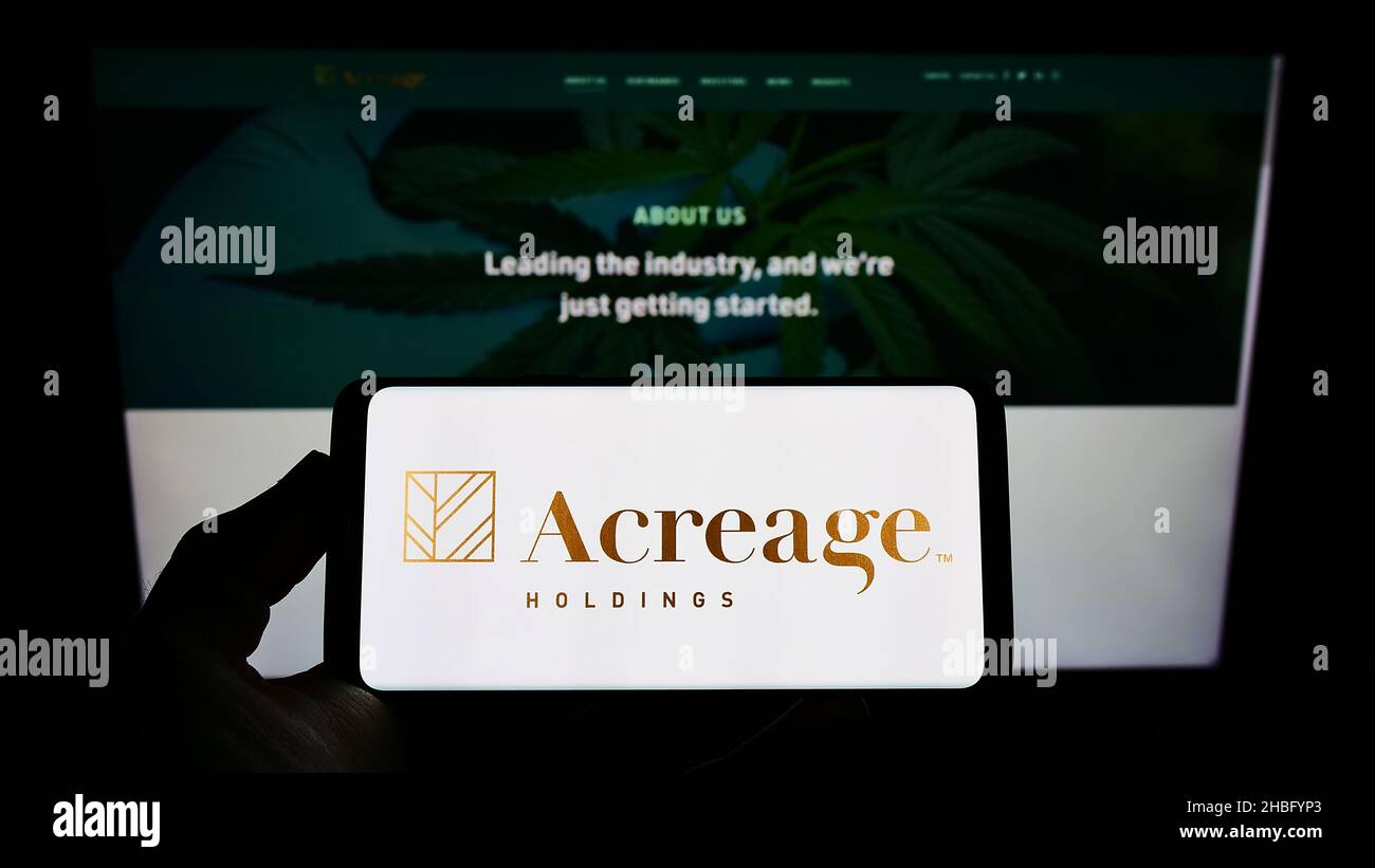 Person, die ein Smartphone mit dem Logo des Cannabisunternehmens Accreage Holdings Inc. Auf dem Bildschirm vor der Website hält. Konzentrieren Sie sich auf die Telefonanzeige. Stockfoto