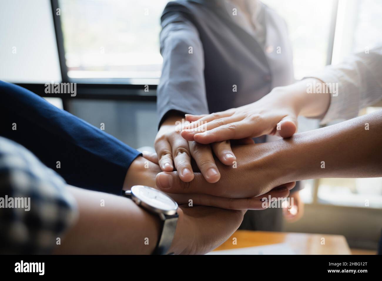 Gruppe von Geschäftsleuten setzen ihre Hände zusammen arbeiten auf hölzernen Hintergrund im Büro. Gruppe unterstützen Teamarbeit Vereinbarung Konzept. Stockfoto