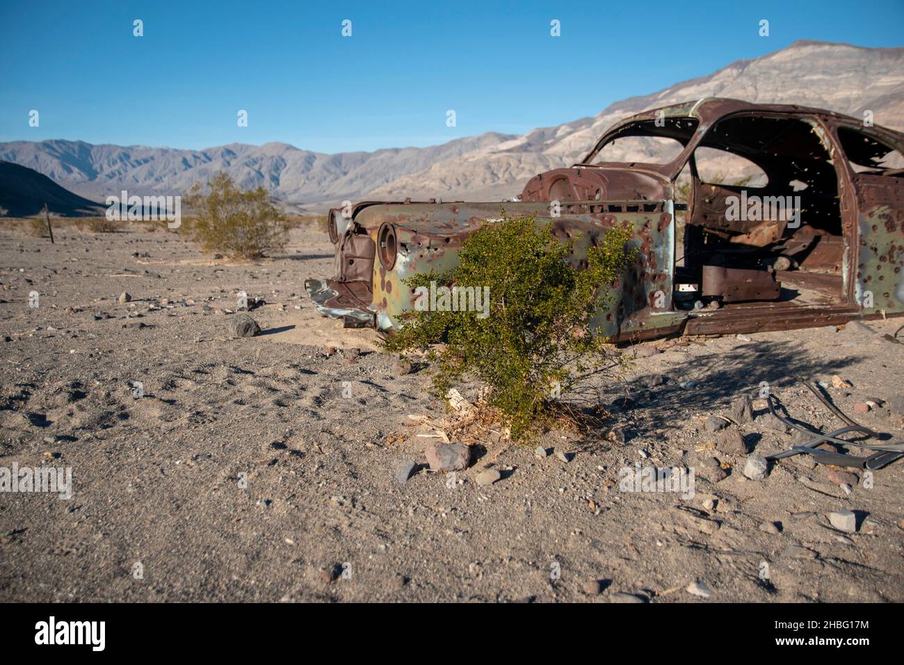 Das Panamint Valley im Death Valley National Park bietet viele interessante Sehenswürdigkeiten, wie rostige Skelette von Autos und die seltene Pfütze, die vom Regen übrig geblieben ist. Stockfoto