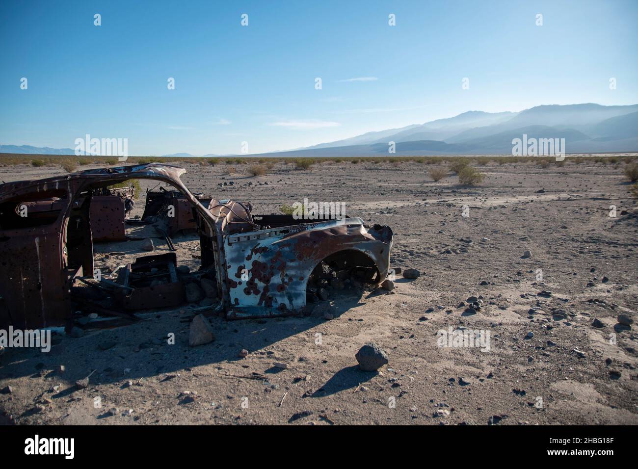 Das Panamint Valley im Death Valley National Park bietet viele interessante Sehenswürdigkeiten, wie rostige Skelette von Autos und die seltene Pfütze, die vom Regen übrig geblieben ist. Stockfoto