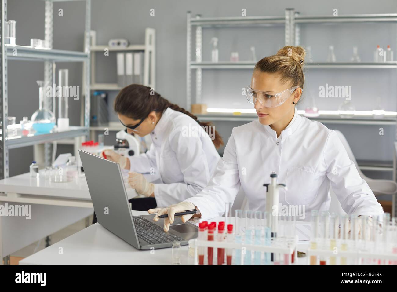 Wissenschaftler, die im modernen Pharmalabor forschen und an einem Laptop arbeiten Stockfoto