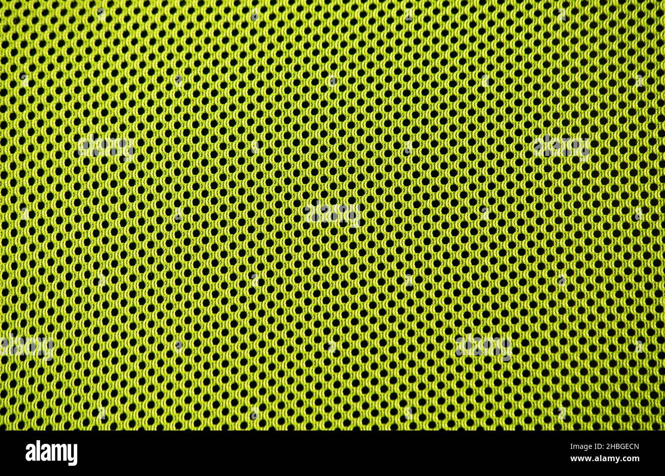 Eine hellgrüne Textur mit Lochmuster. Cooler Hintergrund für Frühlings- und Sommerbilder. Stockfoto