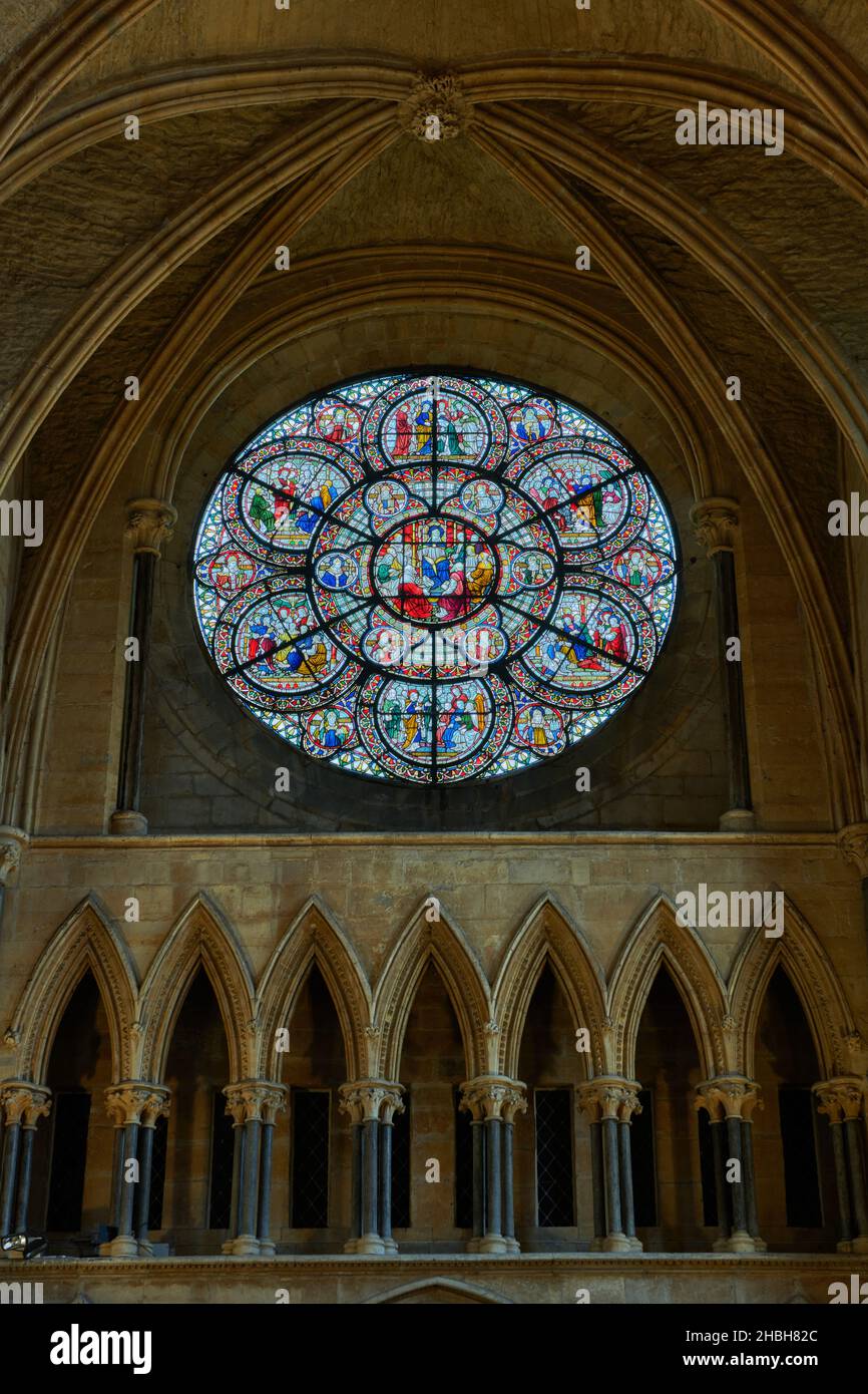 Kreisförmiges Buntglasfenster über spitzen Bögen über dem Eingang zum Kapitelhaus in der Kathedrale von Lincoln, England. Stockfoto