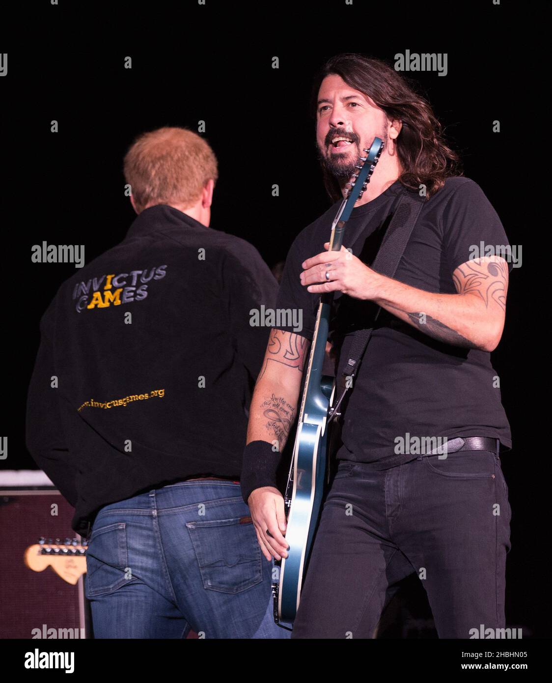 Prinz Harry begrüßt Dave Grohl von den Foo Fighters vor ihrem Auftritt auf der Bühne bei der Abschlussfeier der Invictus Games im Queen Elizabeth Park in East London. Stockfoto