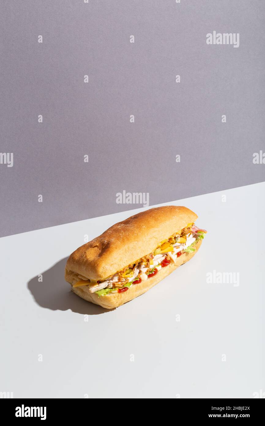 Baguette-Sandwich mit Hühnersalat auf grauem, hartem Schatten Stockfoto