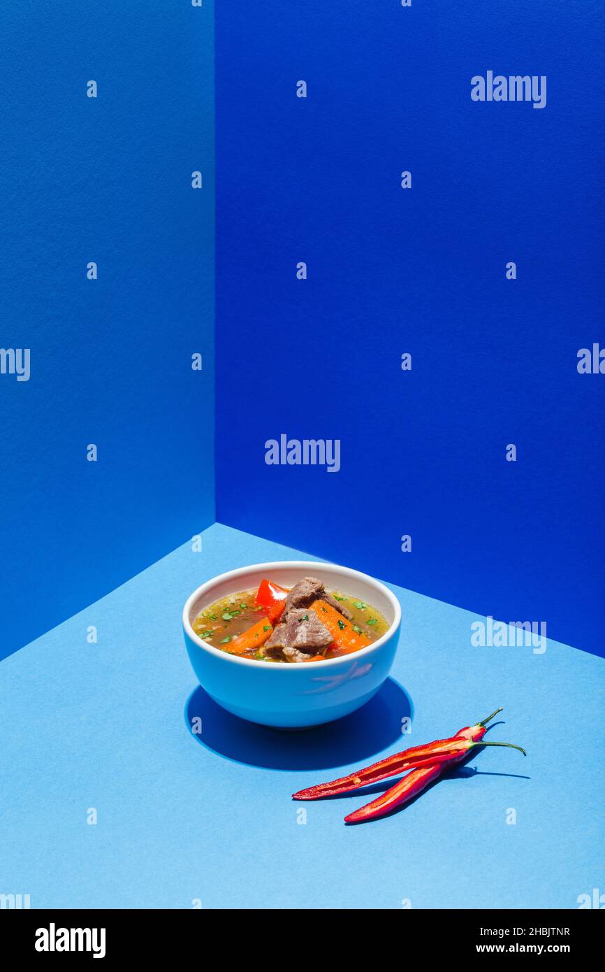 Traditionelle asiatische, usbekische, nahöstliche Suppe mit Rindfleisch oder Lamm und Gemüse. Shorpa, sherpa, Chorba auf Blau Stockfoto