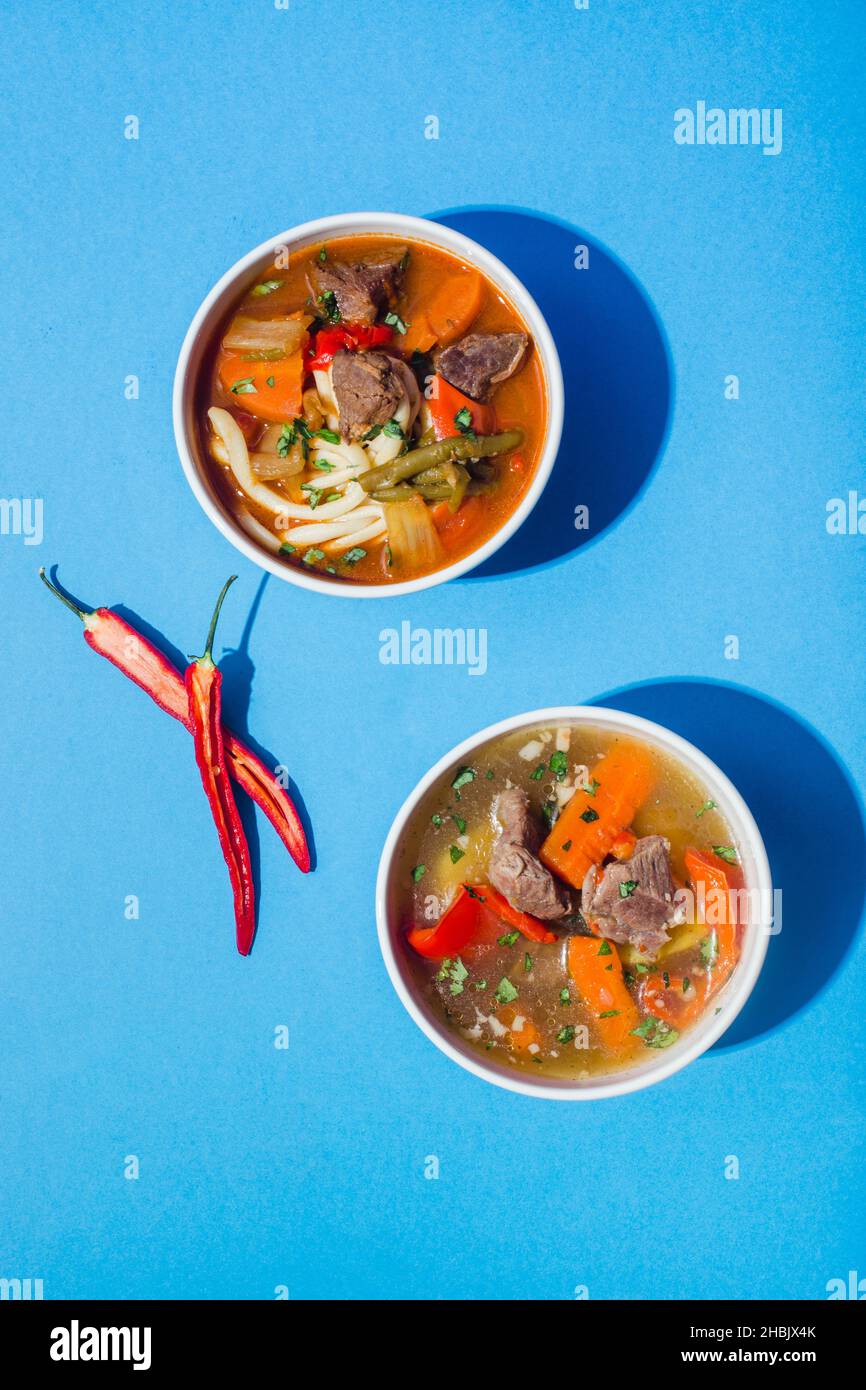 Traditionelle asiatische, usbekische, nahöstliche Suppe mit Rindfleisch oder Lamm und Gemüse. Shorpa, sherpa, Chorba auf Blau Stockfoto