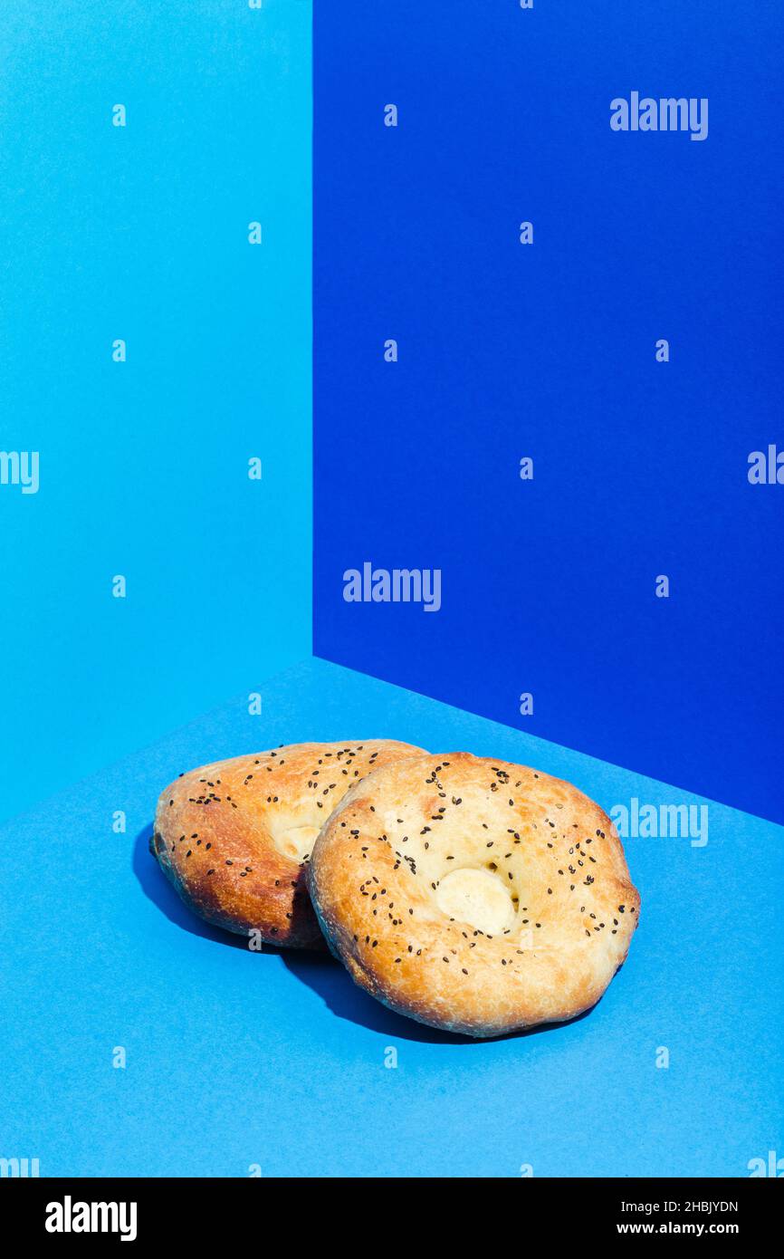 Usbekische Nationalkost Tandyr Brot Lepeshka mit Käse auf blauem Hintergrund minimalistischer Stil Stockfoto