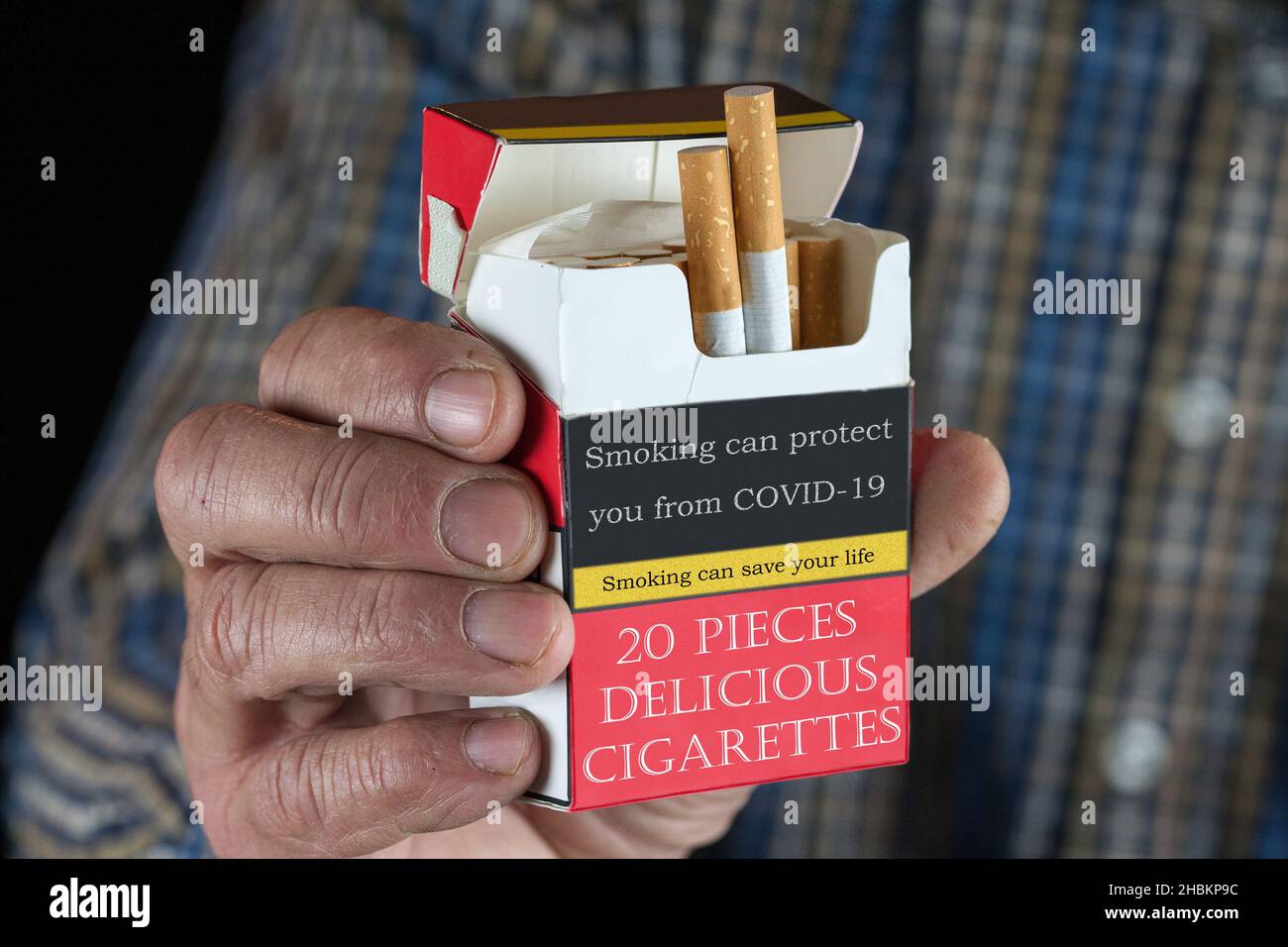 Zigaretten Satire. Raucher bekommen weniger Covid-19. PAK-Substanzen in Zigaretten gelten als krebserregend, aber nach Ansicht der Forscher als krebserregend Stockfoto