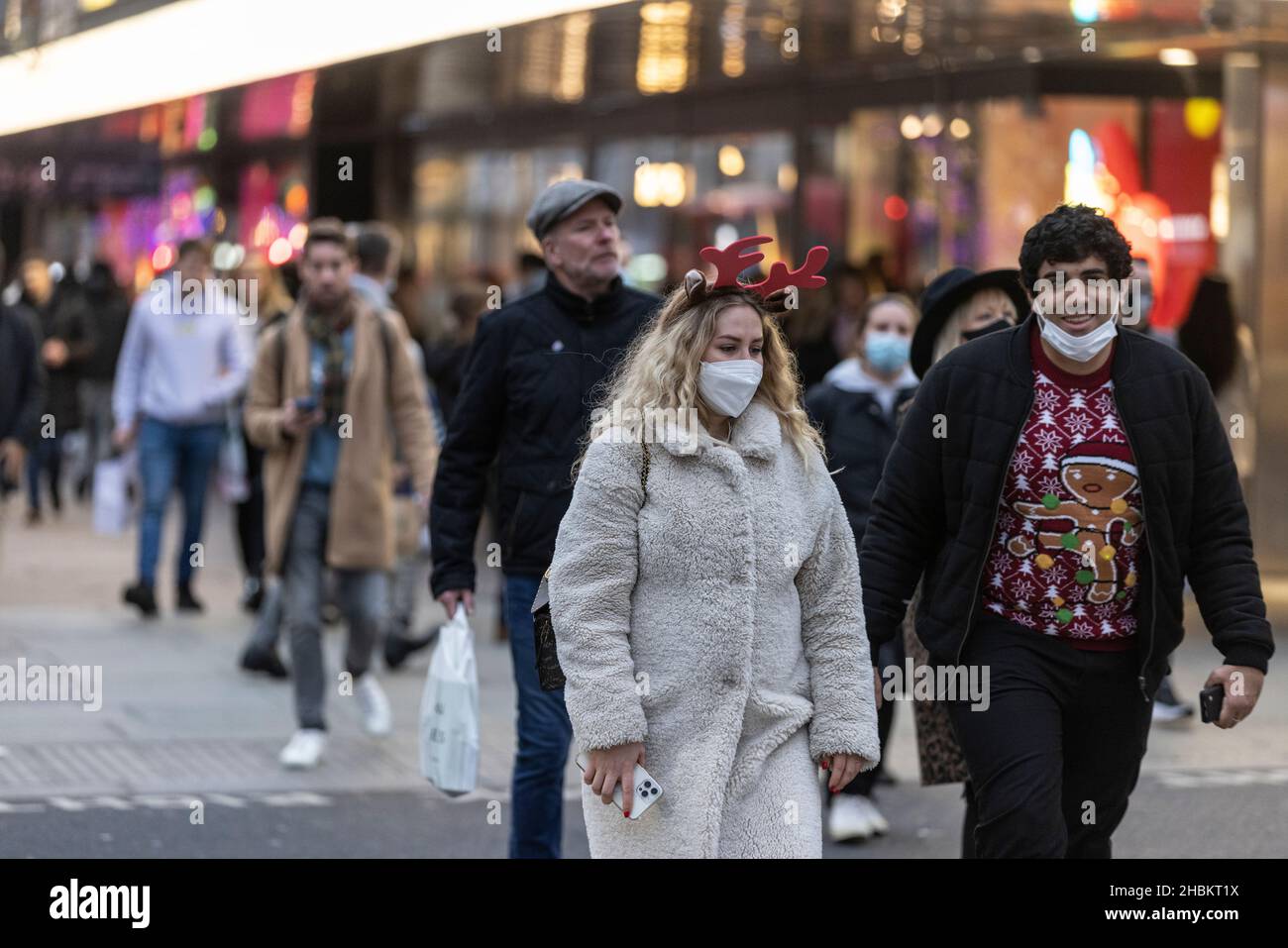 Weihnachtseinkäufer umarmen die Massen auf der Oxford Street vor dem Weihnachtstag, während die Omicron-Gehäuse vor dem festlichen Feiertag weiter spiralförmig werden. Stockfoto