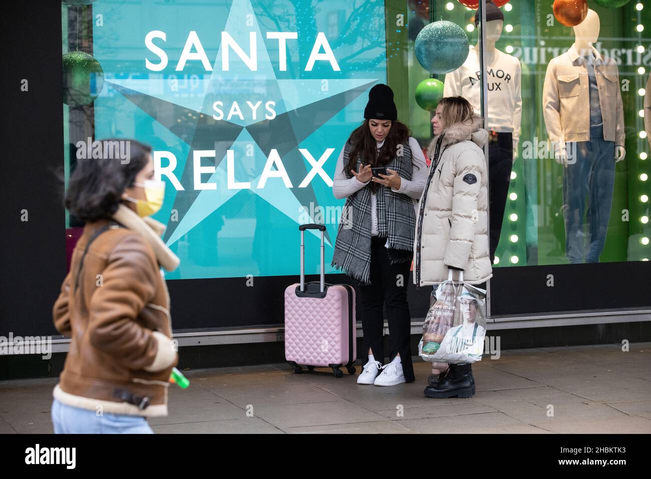 Weihnachtseinkäufer umarmen die Massen auf der Oxford Street vor dem Weihnachtstag, während die Omicron-Gehäuse vor dem festlichen Feiertag weiter spiralförmig werden. Stockfoto
