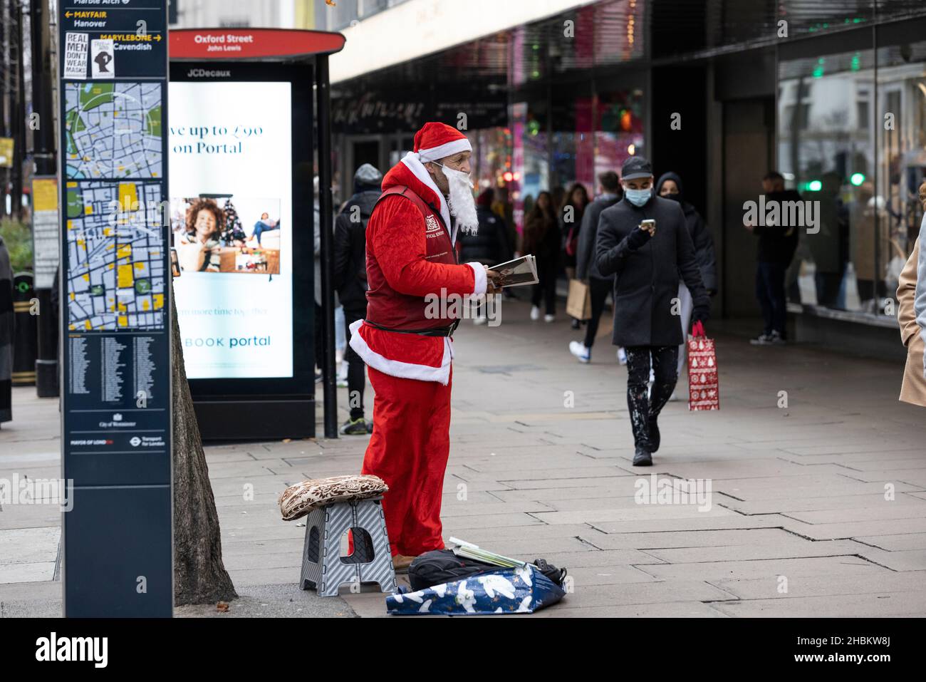 Weihnachtseinkäufer umarmen die Massen auf der Oxford Street vor dem Weihnachtstag, während die Omicron-Gehäuse vor dem festlichen Feiertag weiter spiralförmig werden. Stockfoto