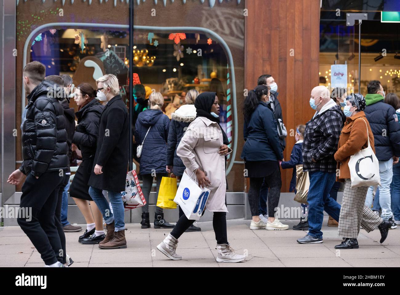 Weihnachtseinkäufer umarmen die Massen auf der Oxford Street vor dem Weihnachtstag, während die Omicron-Gehäuse vor dem festlichen Feiertag weiter spiralförmig werden. Stockfoto