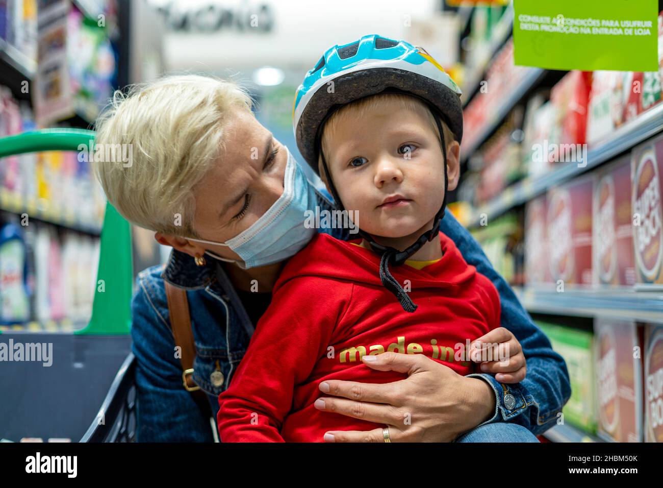 Porto, Portugal - 25. September 2021: Mutter beim Maskeneinkauf mit ihrem 3-jährigen Sohn im Supermarkt Stockfoto