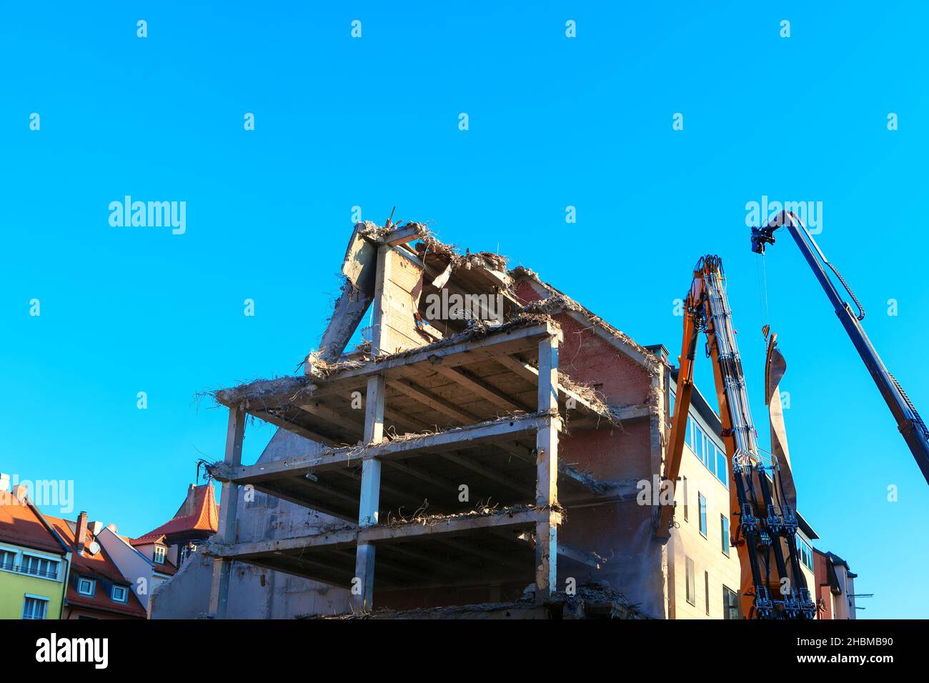 Abriss eines Gebäudes in der Stadt. Dekonstruktion hydraulische Brechmaschine . Ruiniertes Haus Stockfoto