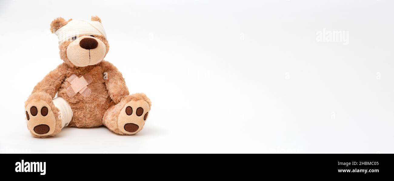 Teddybär mit Bandage, kindermedizinisches Betreuungskonzept. Bär auf weißem Hintergrund Stockfoto
