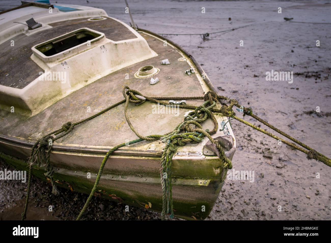 Am Ufer des Gannel River in Newquay in Cornwall wurden die Überreste eines alten Segelbootes, das auf Reparatur wartet, zusammengebunden. Stockfoto