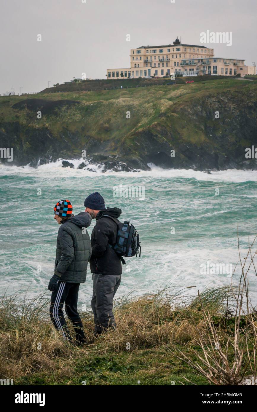 Menschen, die auf Towan Head stehen und das wilde Wetter und die wilden Meere in Newquay Bay beobachten, die durch den Sturm Arwen in Cornwall verursacht wurden. Stockfoto