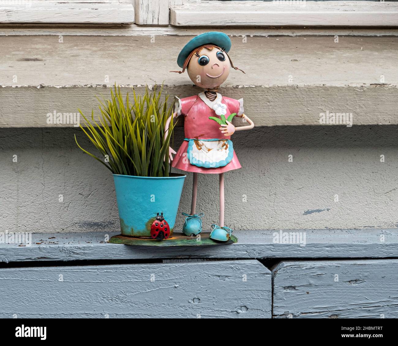 Gartenschmuck und Topfpflanze auf Fensterleiste im Vorstadtgarten in Pankow, Berlin Stockfoto