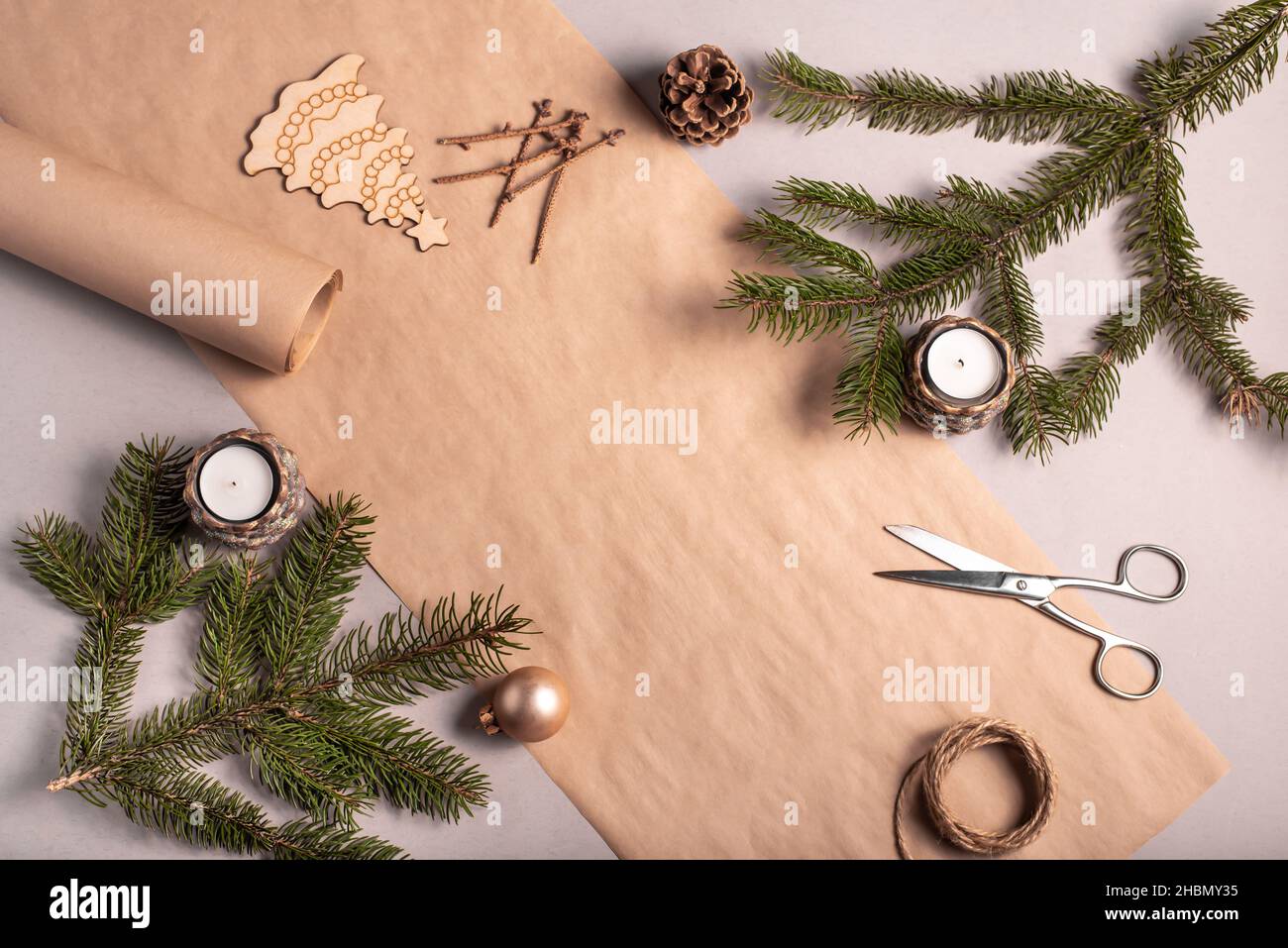Verpackung ein Geschenk für Weihnachten und Neujahr in umweltfreundlichen Materialien: kraftpapier, lebende Tannenzweige, Kegel, Garn. Tags mit nachgemaltenem, natürlichem Dekor Stockfoto