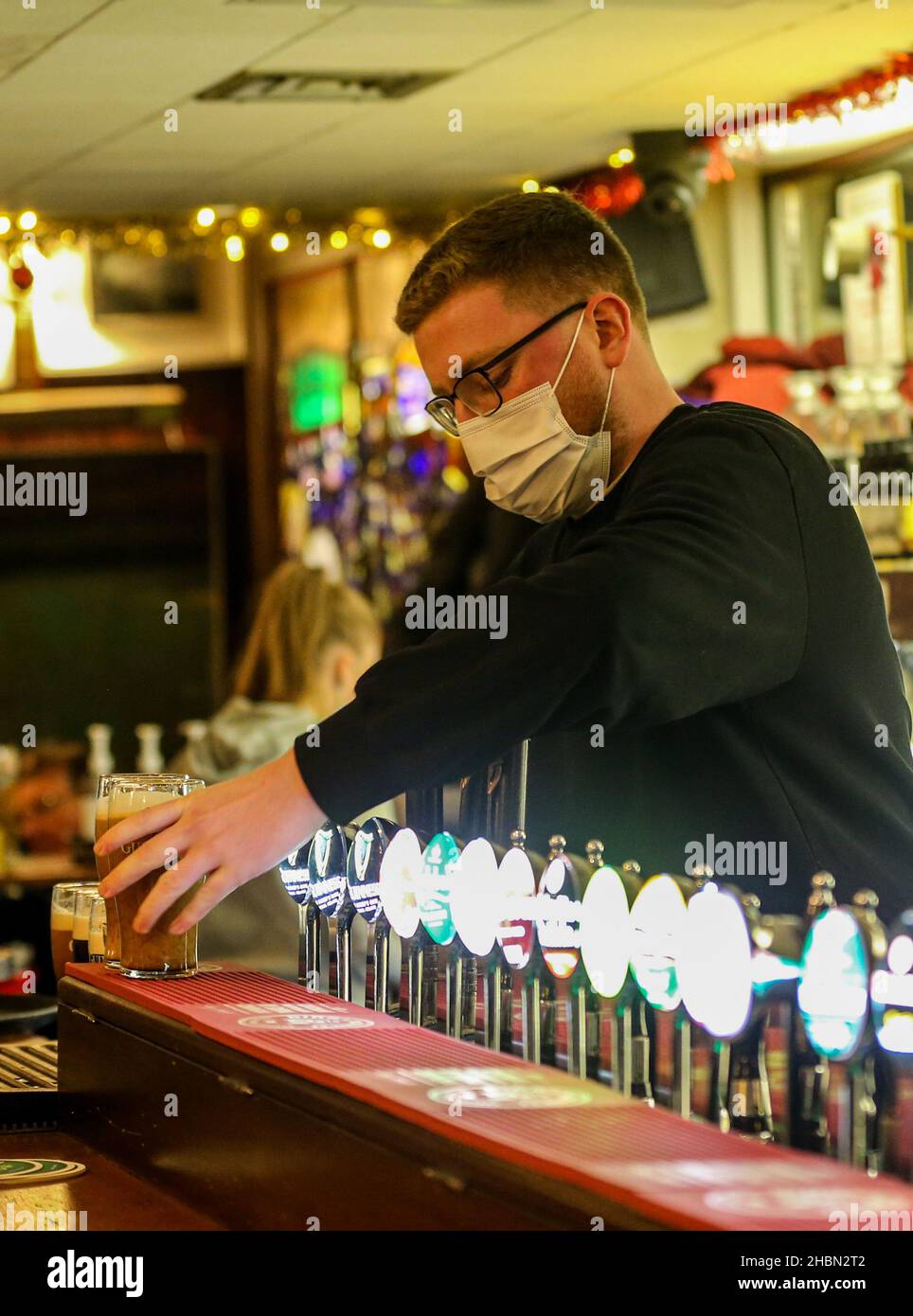 Daniel Smith von der Grogans Bar serviert Getränke in der Grogans Bar in Dublin, bevor die Pubs und Restaurants in Irland ab heute Abend 8pm geschlossen haben. Bilddatum: Montag, 20. Dezember 2021. Siehe PA-Geschichte IRISCHES Coronavirus. Bildnachweis sollte lauten: Damien Storan/PA Wire Stockfoto