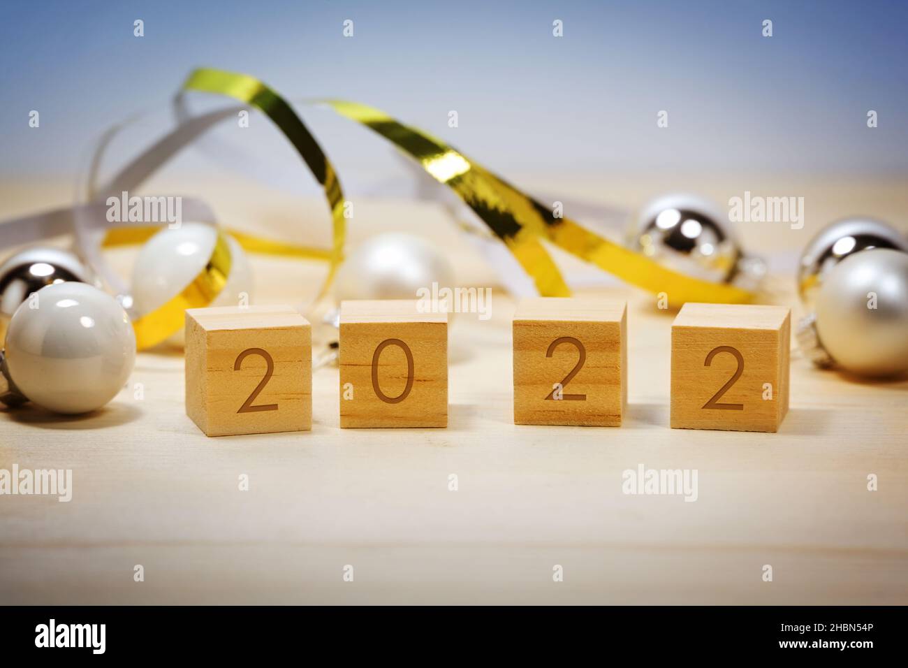 Hölzerne Zahlenwürfel zeigen das neue Jahr 2022, Weihnachtsdekoration vor blauem Hintergrund, Kopierraum, ausgewählter Fokus, enge Schärfentiefe Stockfoto