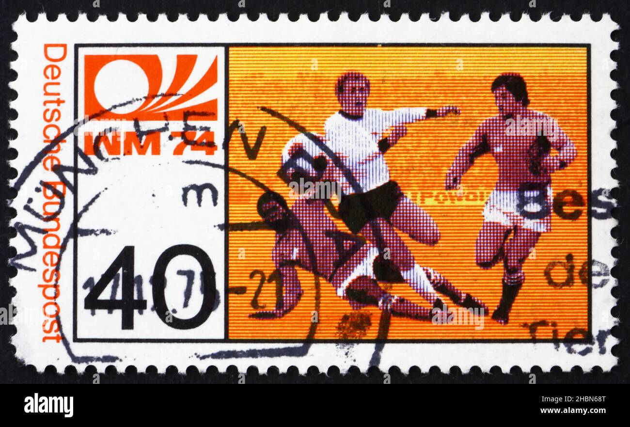 DEUTSCHLAND - UM 1974: Eine in Deutschland gedruckte Marke zeigt drei Fußballspieler, Fußball-WM, München, um 1974 Stockfoto