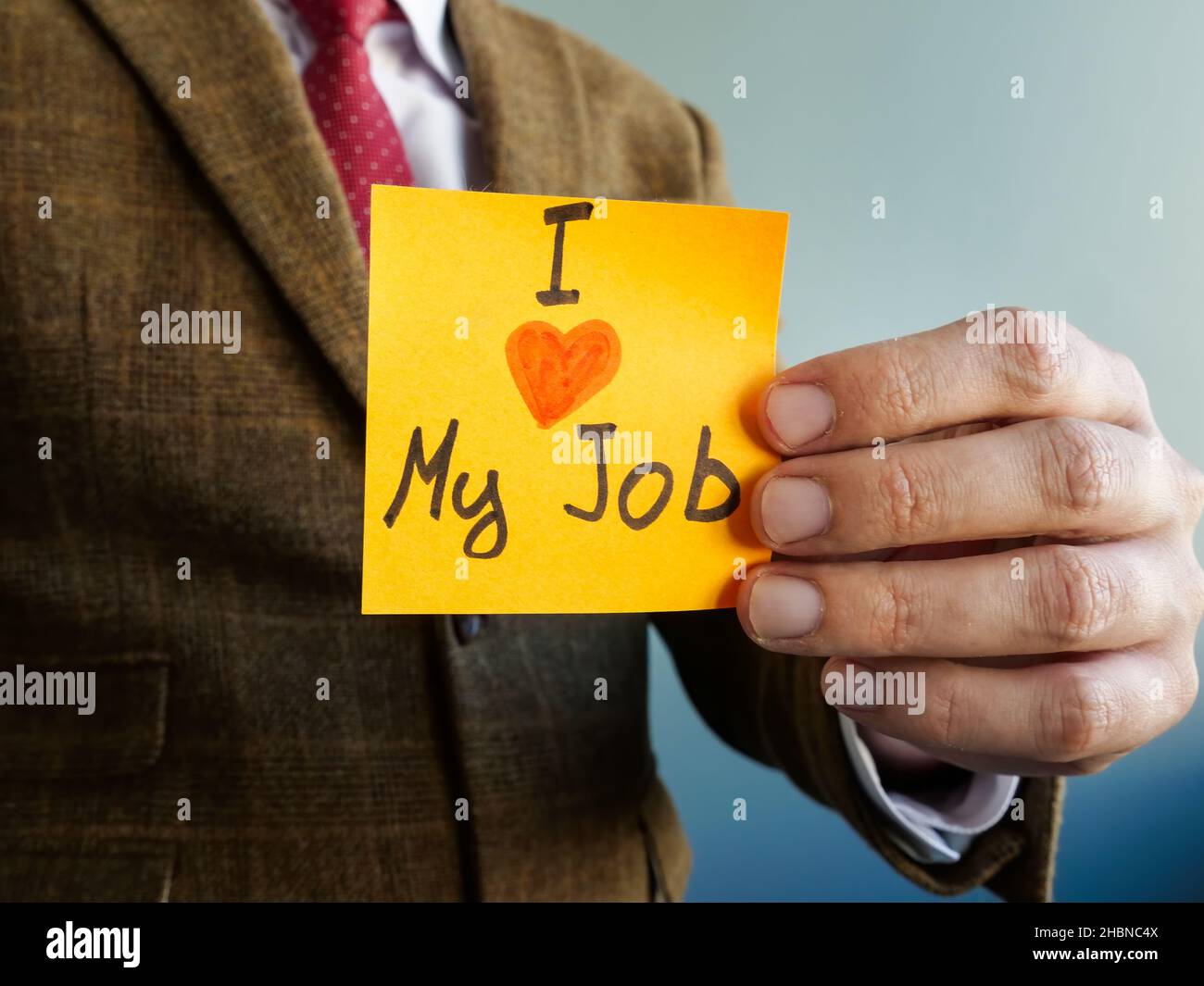 Mann zeigt Schild Ich liebe meinen Job. Konzept zur Mitarbeiterzufriedenheit. Stockfoto