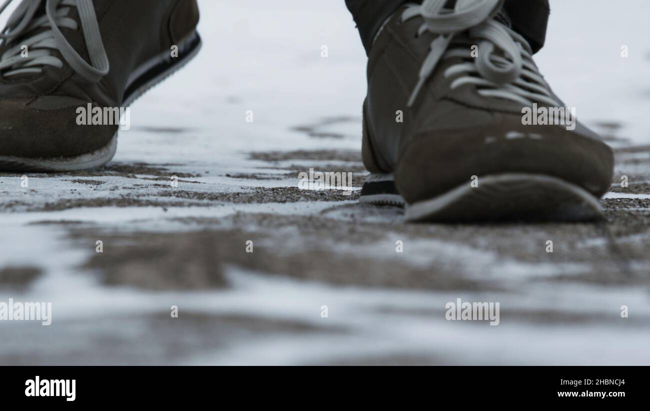 Nahaufnahme von männlichen Beinen in Winterschuhen, die auf Schnee laufen. Blick auf das Wandern auf Schnee mit Schneeschuhen und Schuhspitzen im Winter. Herrenbeine in Stiefeln aus nächster Nähe Stockfoto