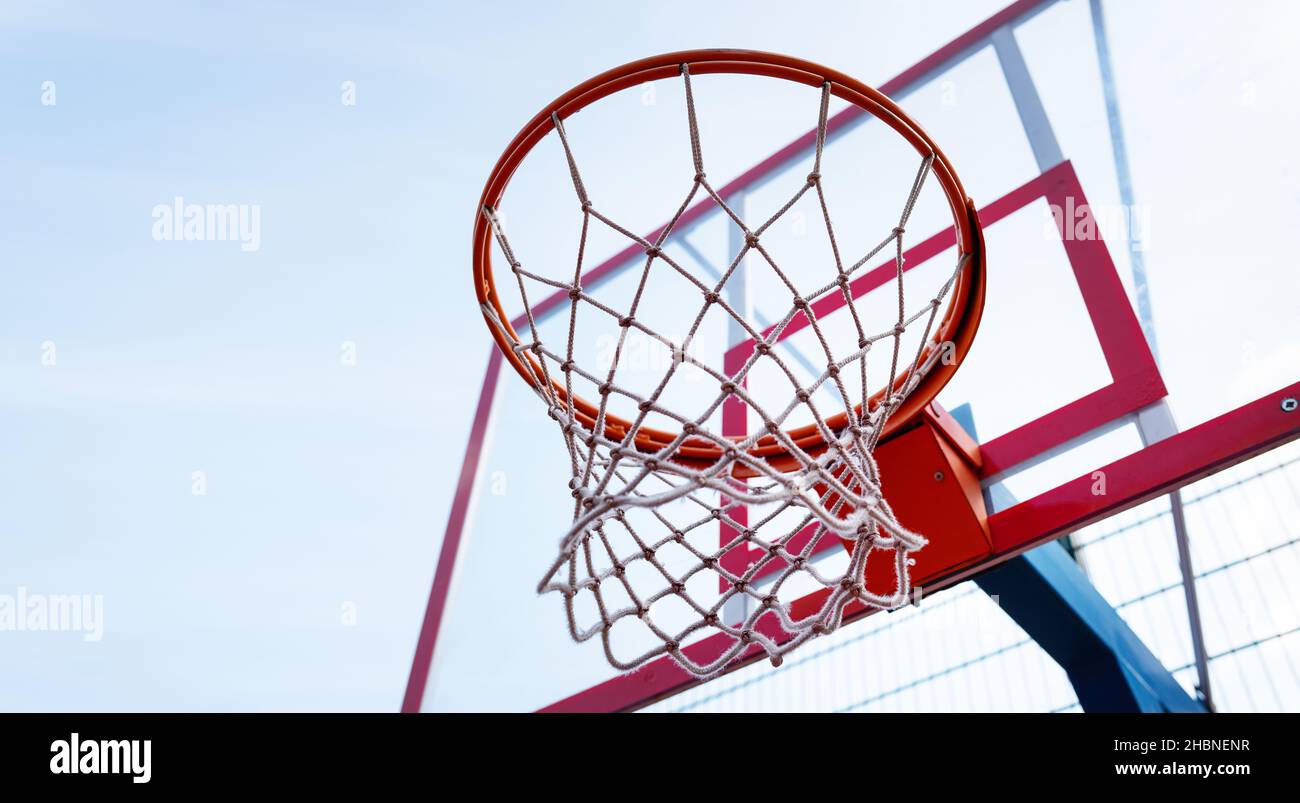 Basketballkorb aus der Nähe in der Sporthalle, Ansicht von unten. Vor dem  Hintergrund eines sonnigen blauen Himmels Stockfotografie - Alamy