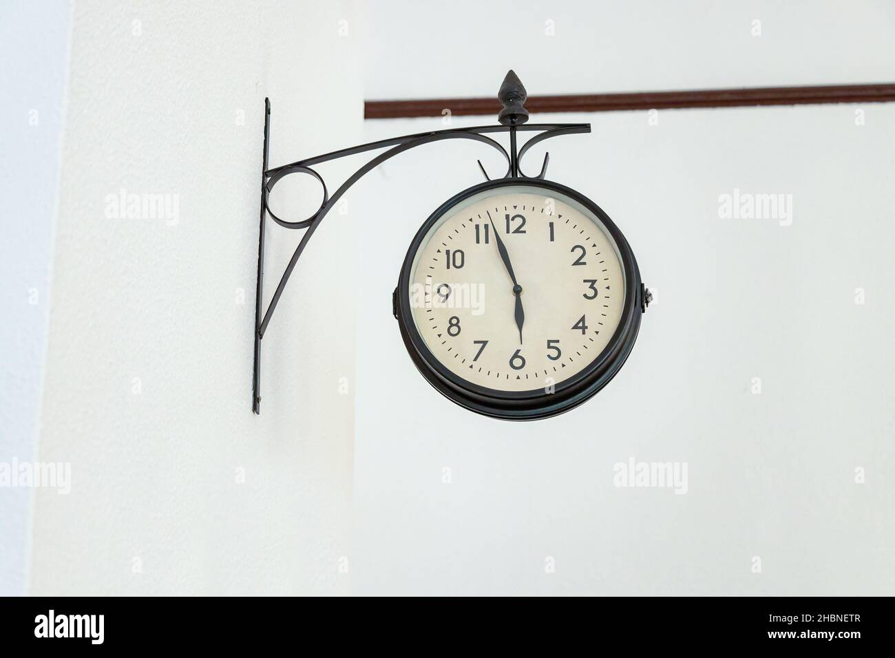 Alte Wanduhr über einer weißen Wand Stockfoto