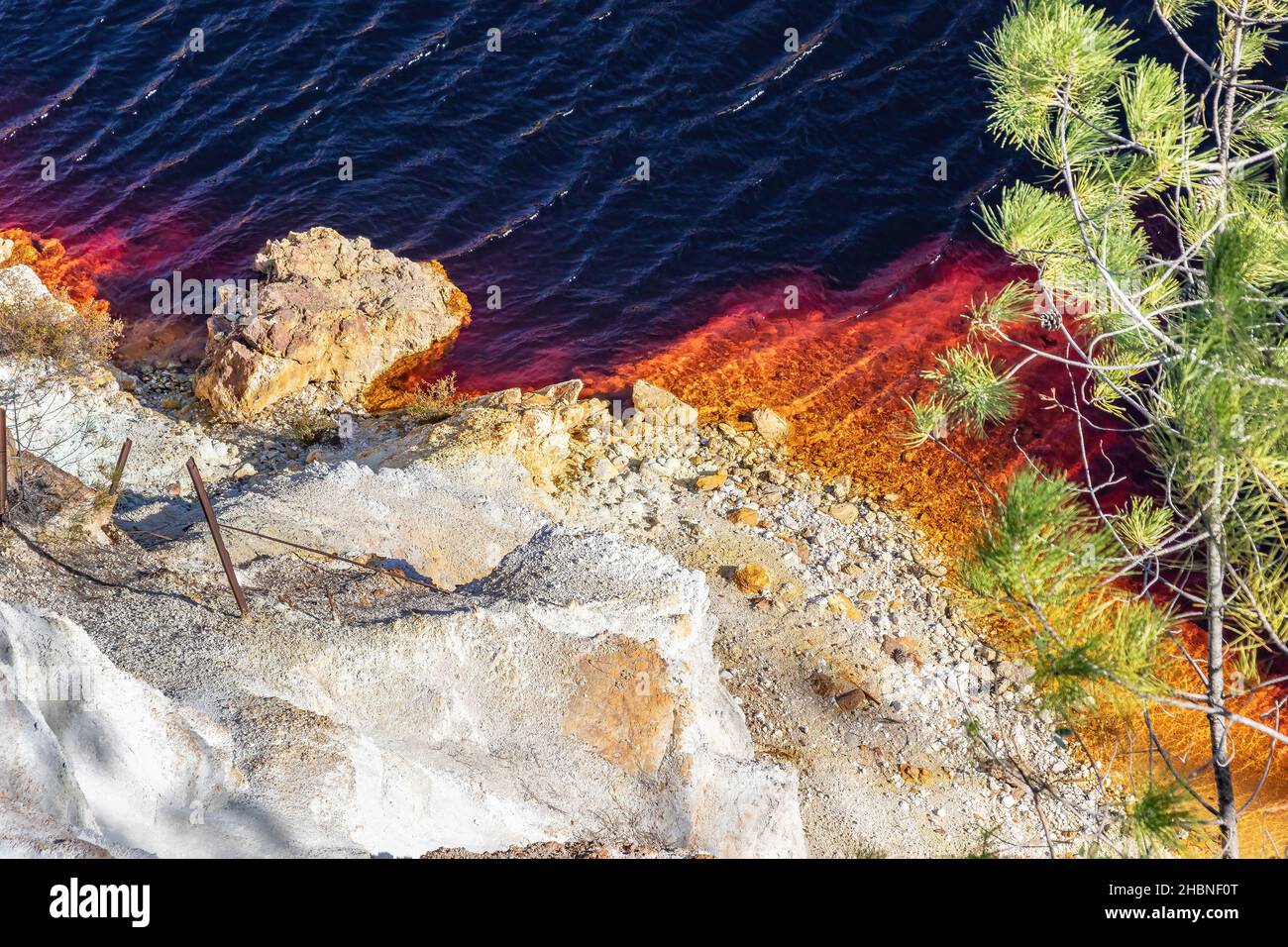 Detail der Tagebaugrube Peña del Hierro mit dem roten Wasser aufgrund der Kupfer- und Eisenkonzentration. Tiefaushub von Pyrit und Gewinnung von Mineralien Stockfoto