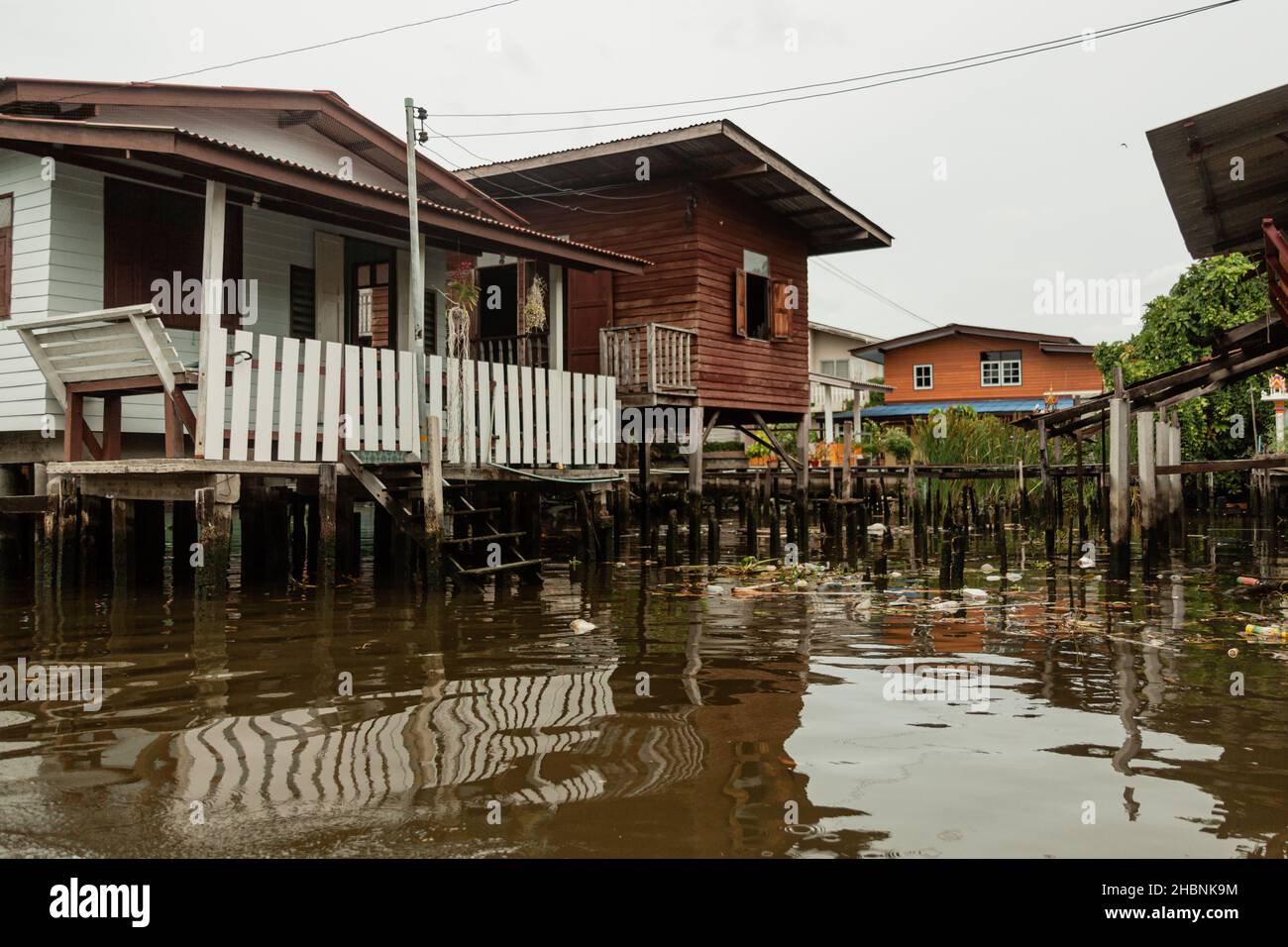 Häuser auf dem Wasser und Müll schwimmt auf der Wasseroberfläche, Bangkok, Thailand Stockfoto