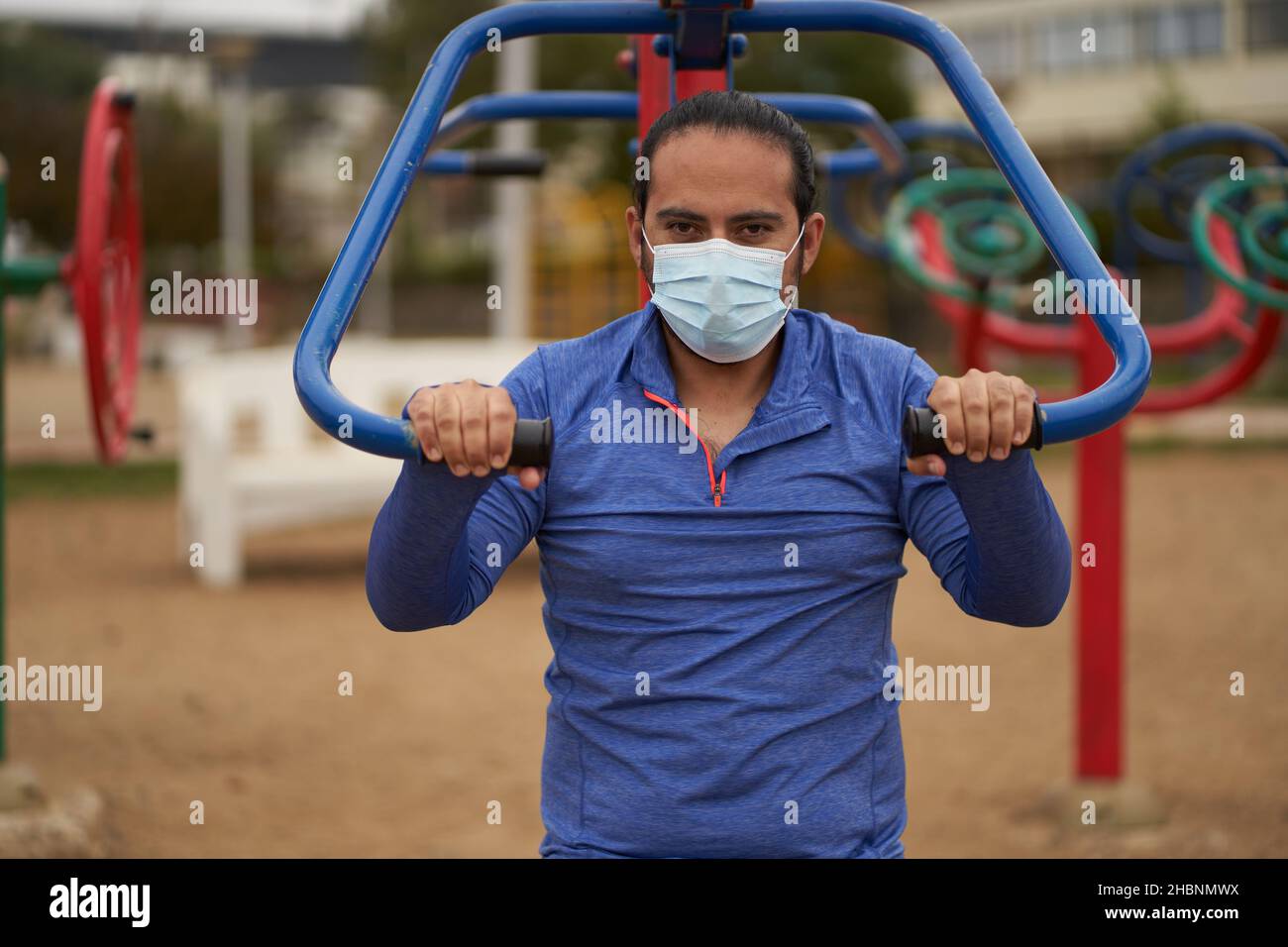 New Normal. Mann führt Liegestütze mit einem Gesichtsmask oder Kinnriemen und Sportkleidung. Mann trainiert im Park. Stockfoto