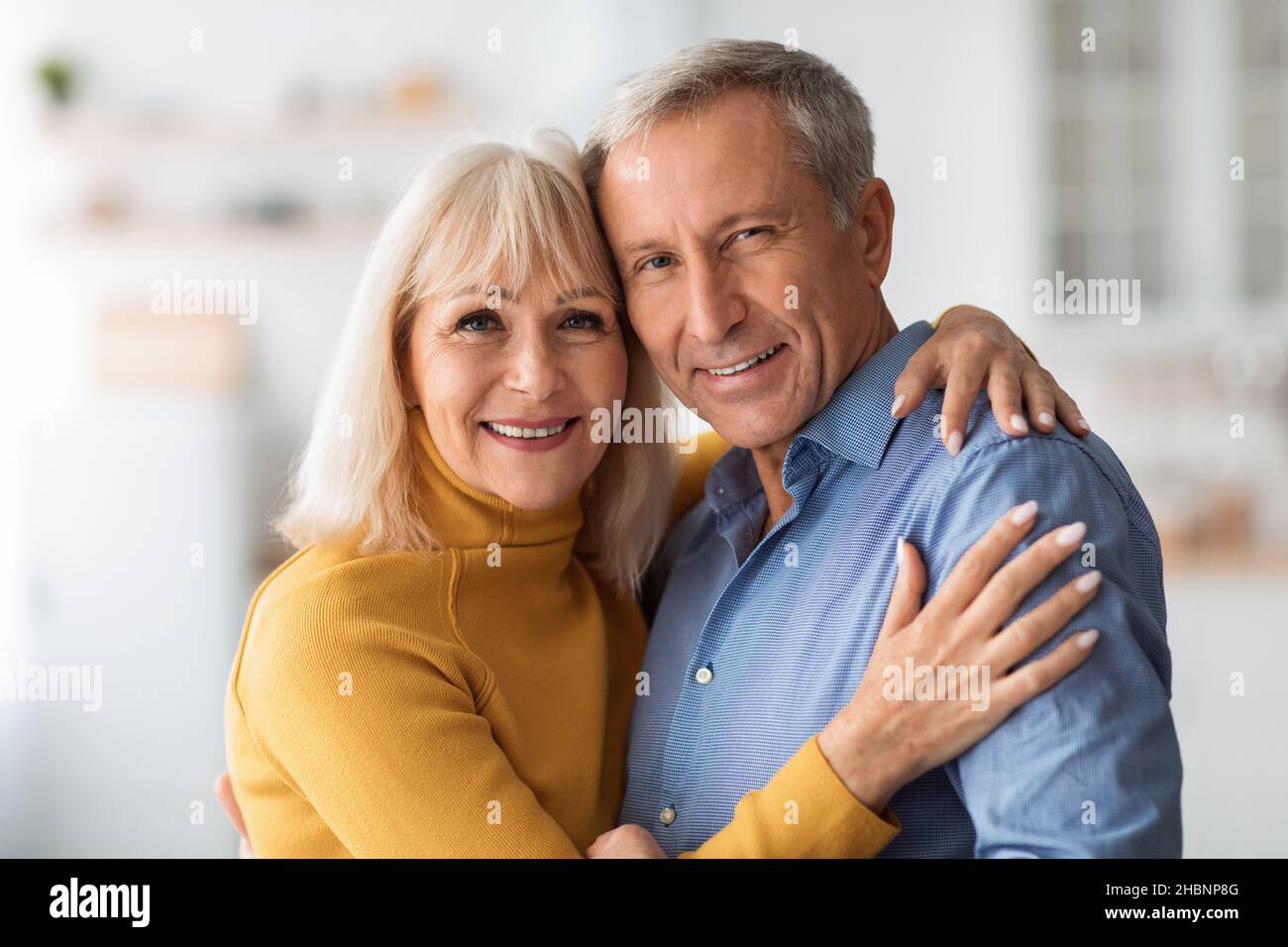 Liebevolle Reife Ehepartner Umarmen Lächelnd Stehen In Der Küche Zu Hause Stockfoto