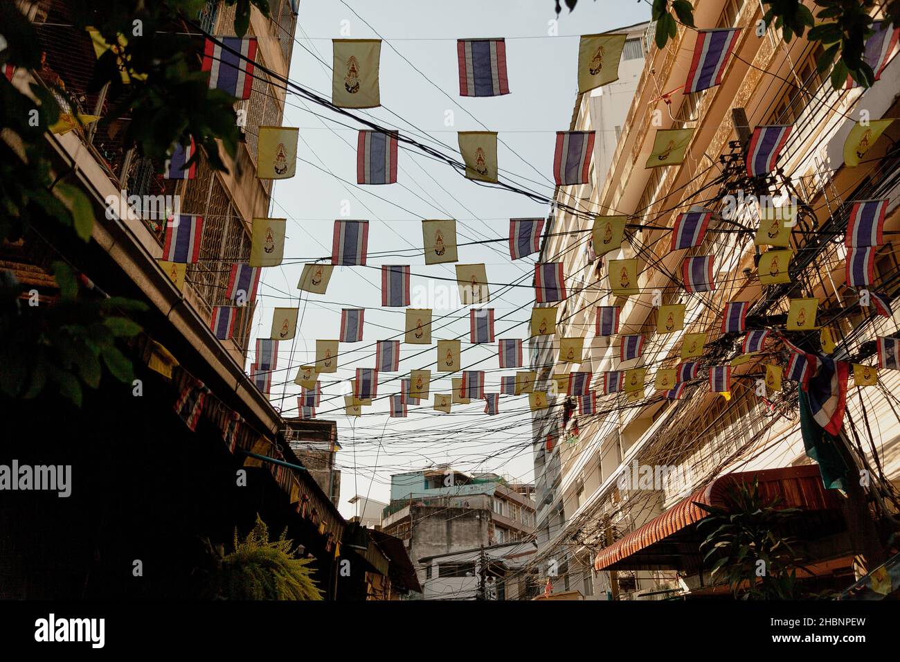 Kleine Flaggen, die an Drähten über der Straße angebracht sind, Bangkok, Thailand Stockfoto