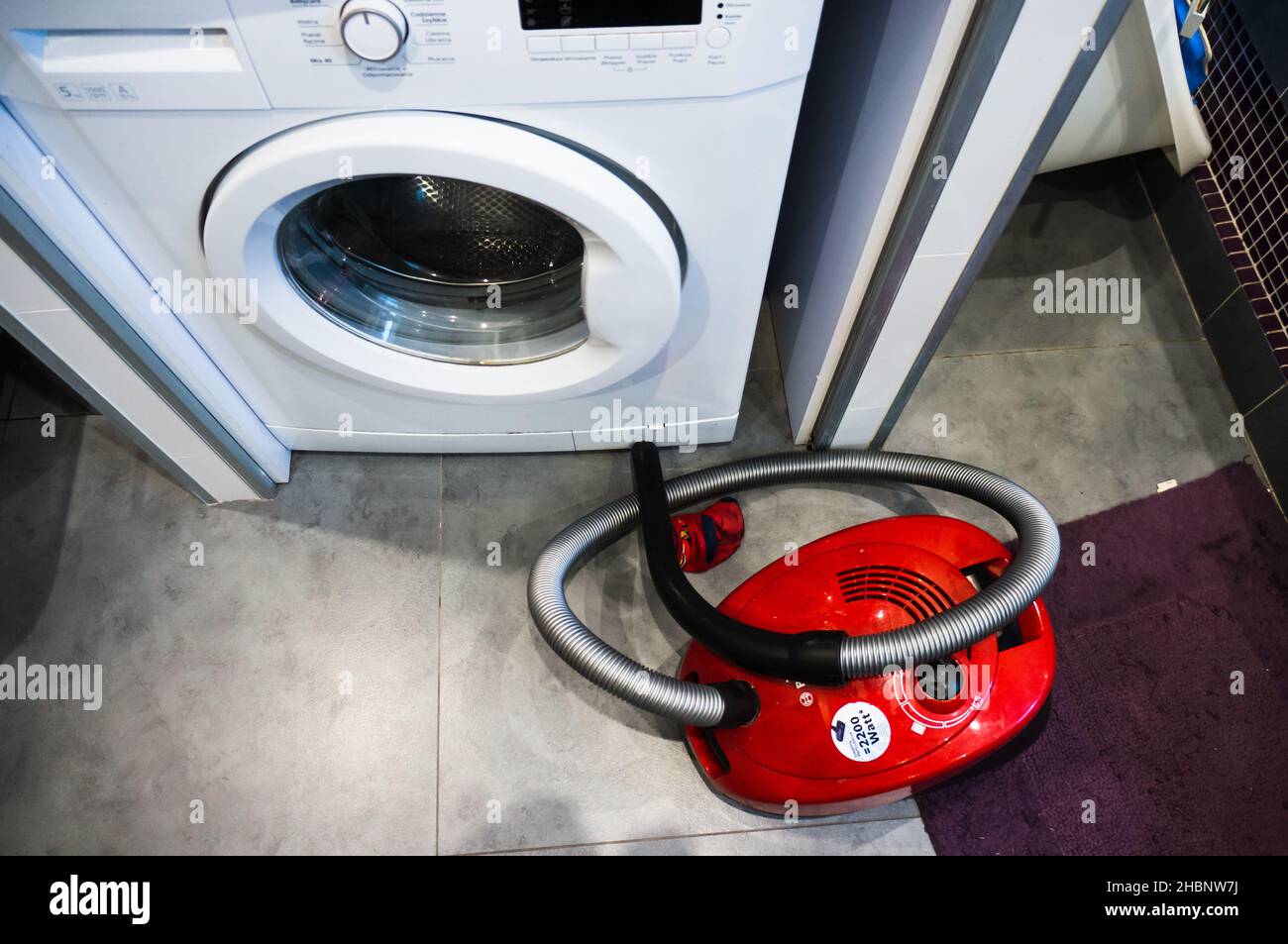 POZNAN, POLEN - 10. Mai 2019: Draufsicht auf einen roten Bosch-Staubsauger neben einer Waschmaschine der Marke Beko Stockfoto