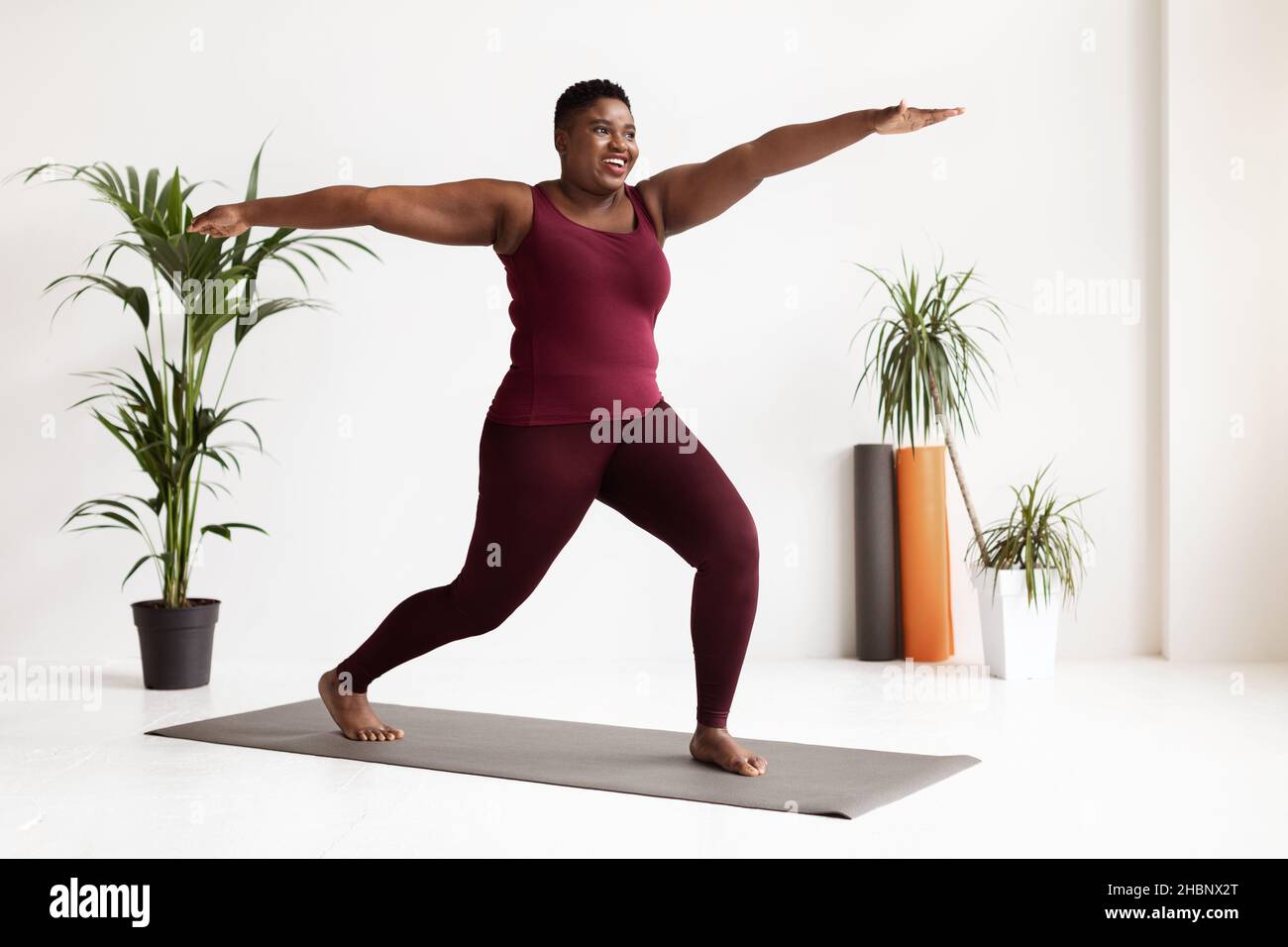 Motivierte schwarze Frau in Sportswear, die Übungen macht, Ganzkörperschuss Stockfoto