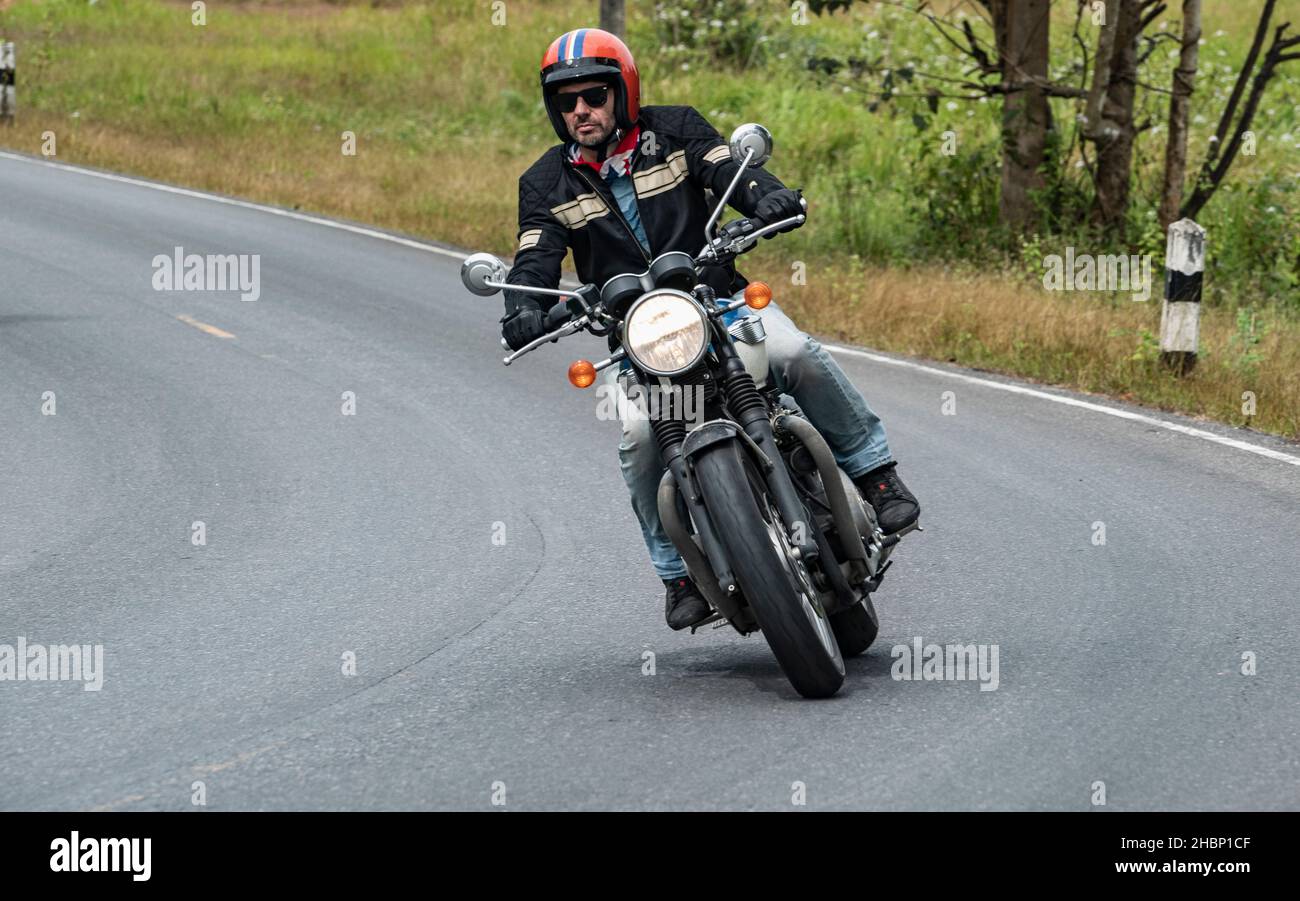 Mann auf seinem klassischen Motorrad im Khao Yai Nationalpark Stockfoto