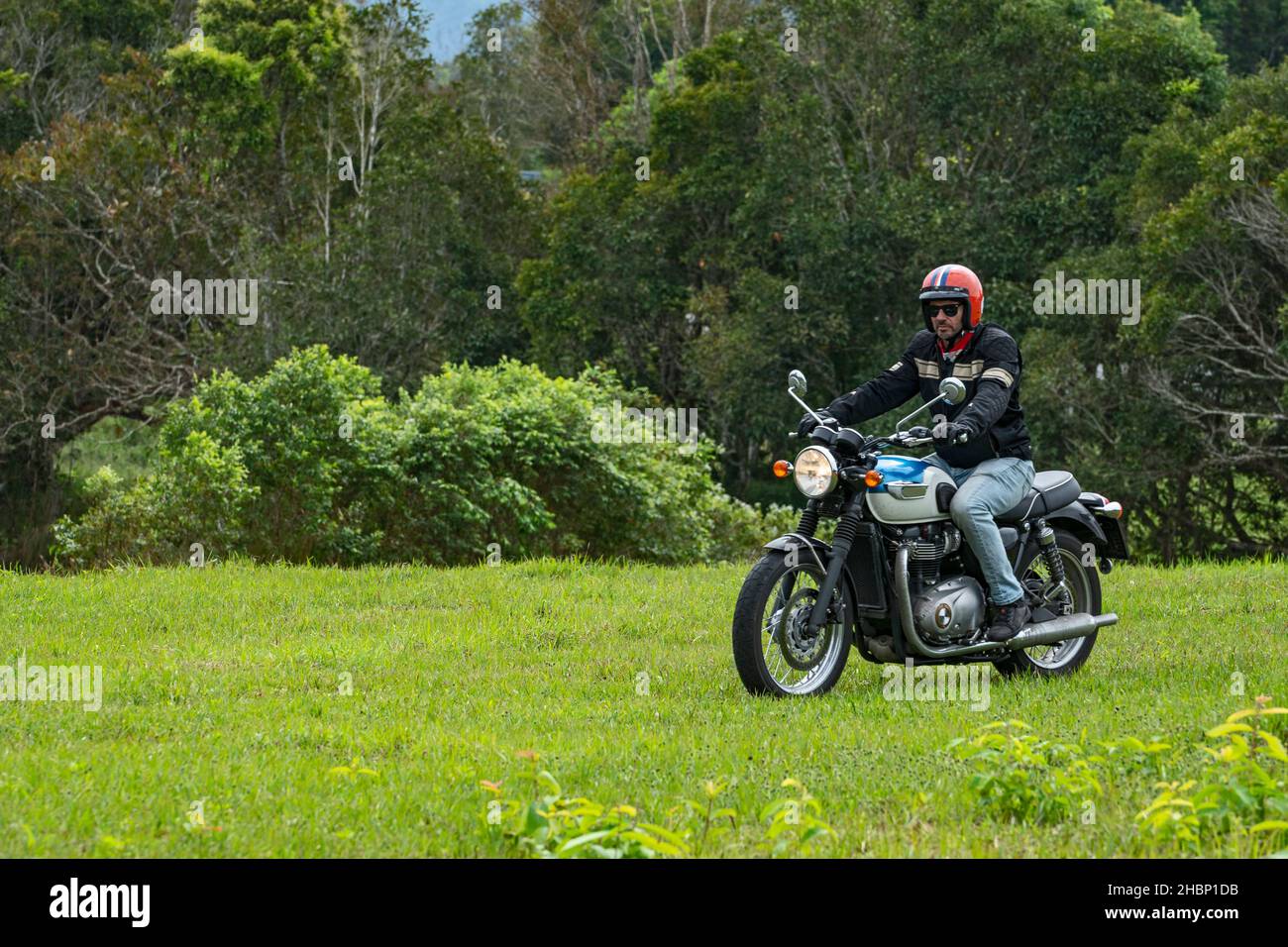 Mann auf seinem klassischen Motorrad im Khao Yai Nationalpark Stockfoto